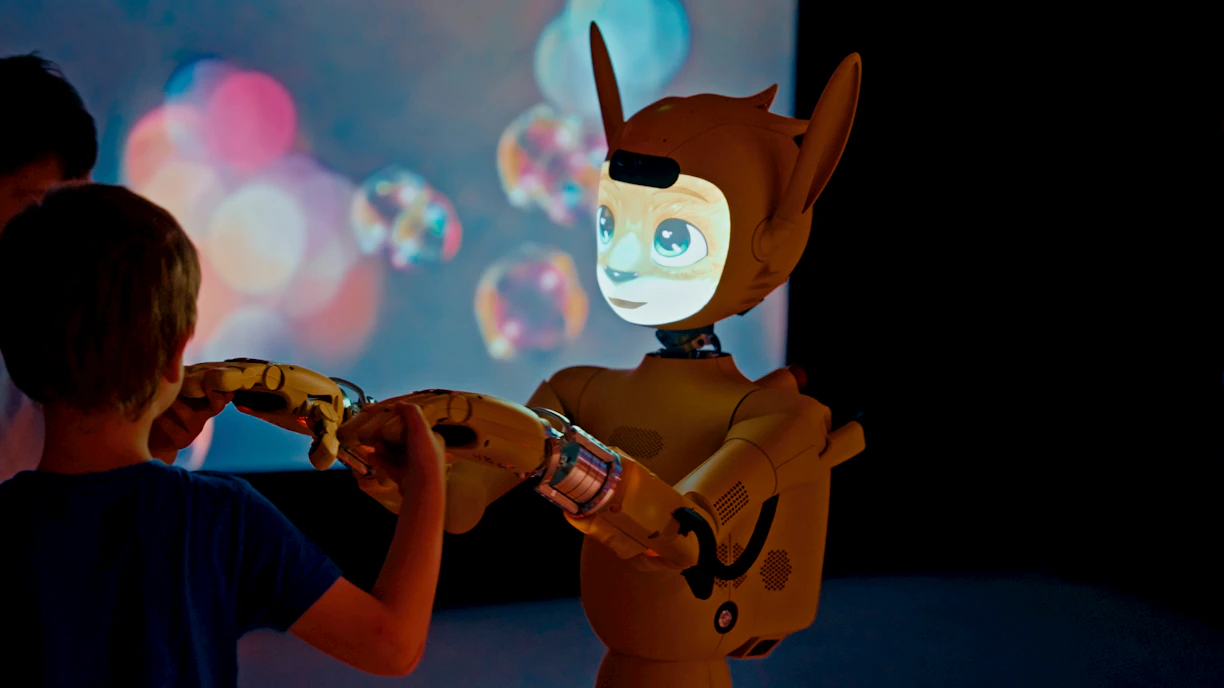 Child and robot interacting with projected bubbles