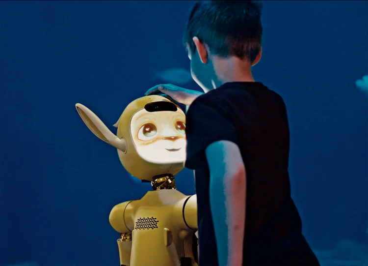 Kids patting head of animated robot