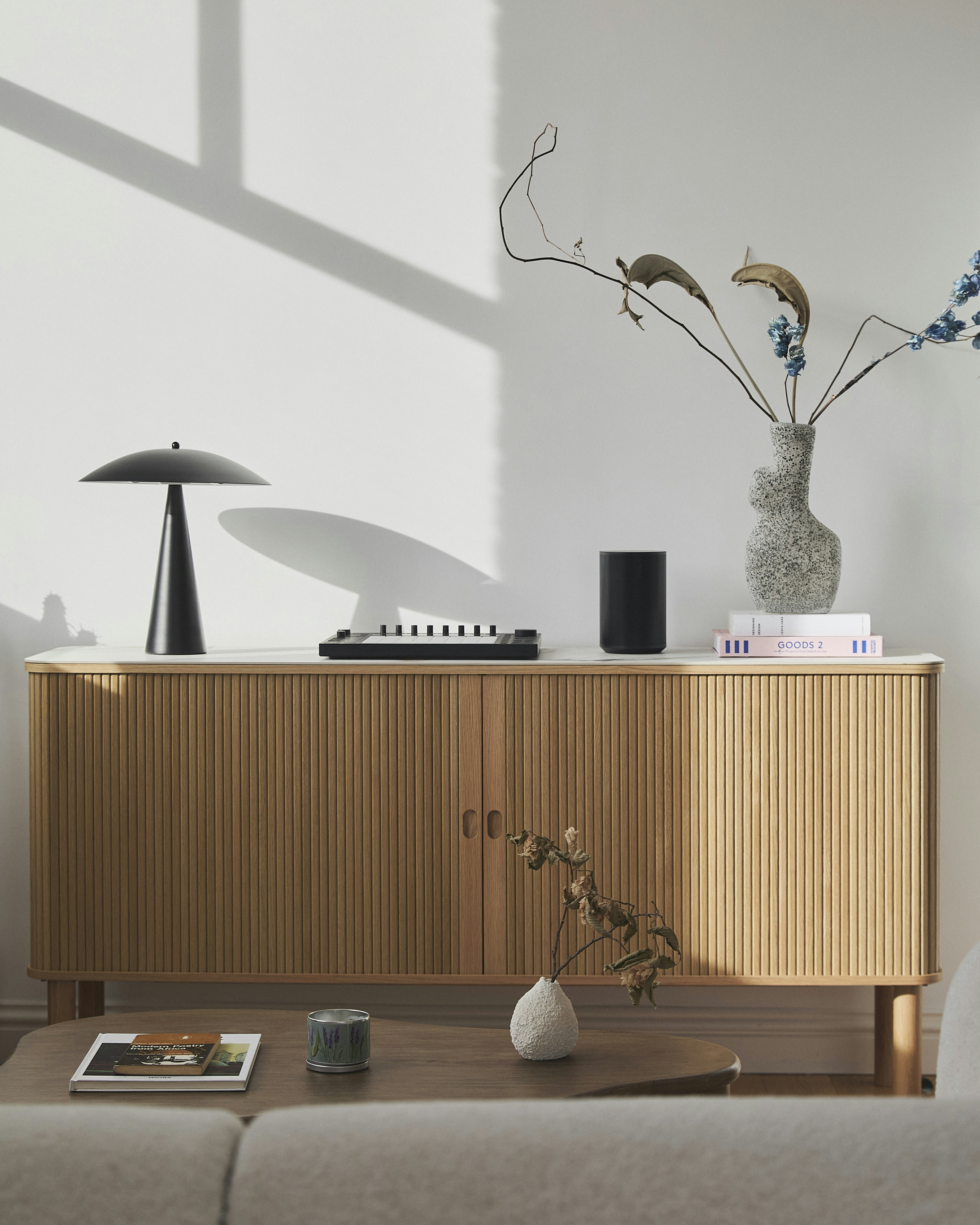 Modern wooden sideboard with decorative items and lamp.