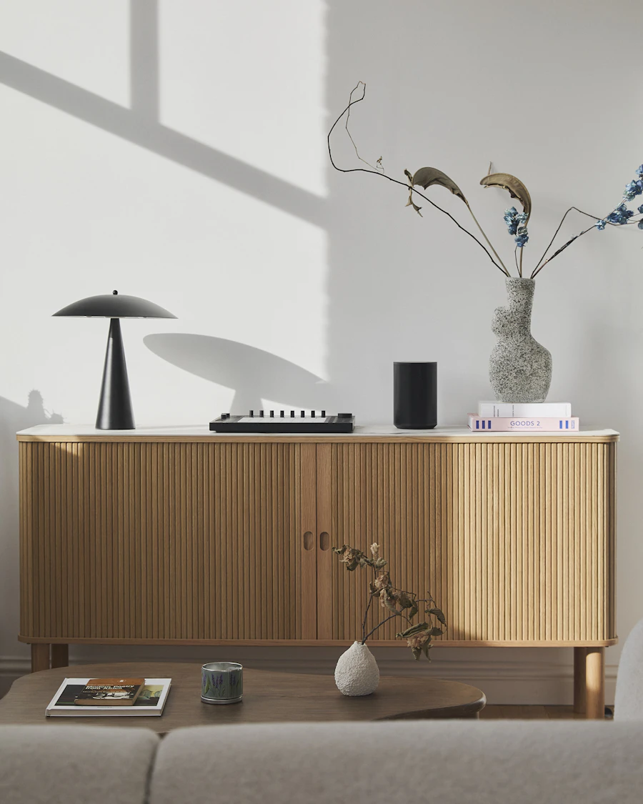 Ribbed oak sideboard with a table lamp