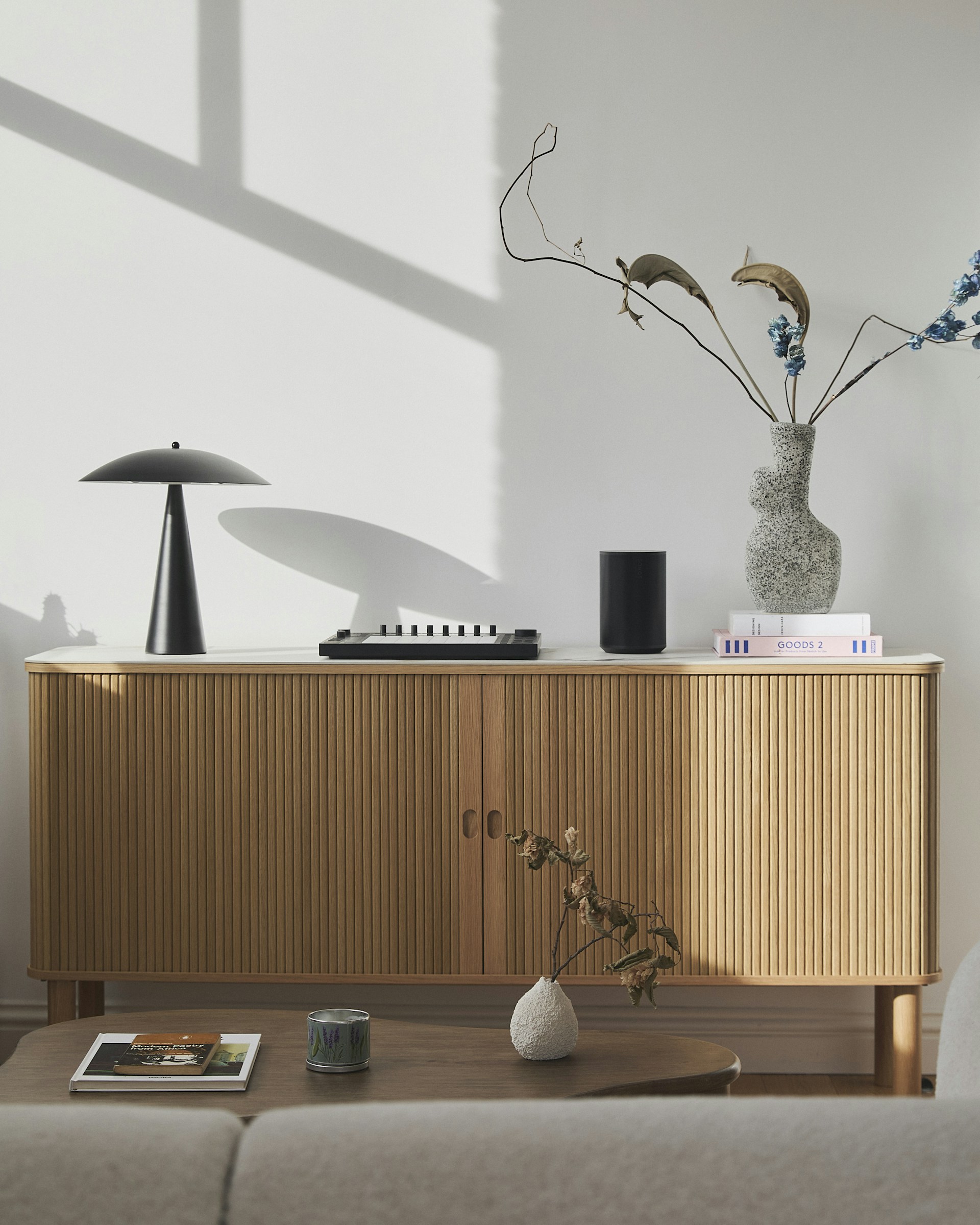 Modern wooden sideboard with decorative items and lamp.