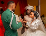 Groom places ring on bride's finger during wedding ceremony