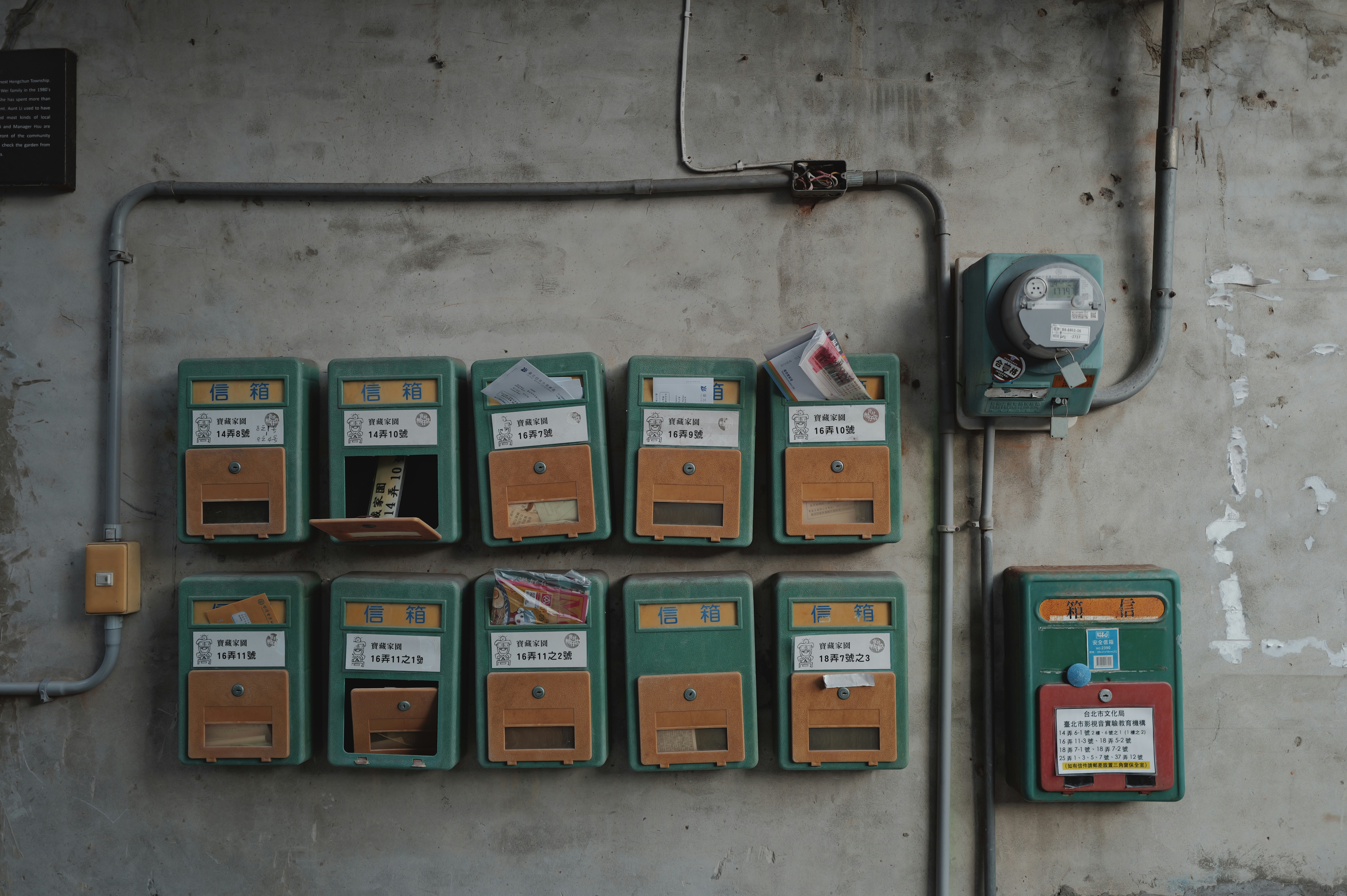 Row of old mailboxes on a textured wall.