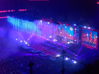 Concert stage with blue lights and large screens