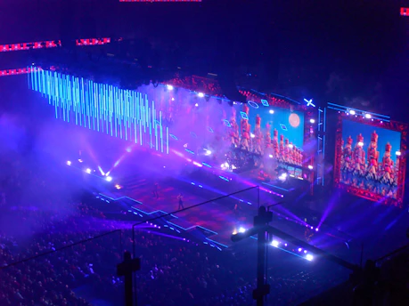 Concert stage with blue lights and large screens