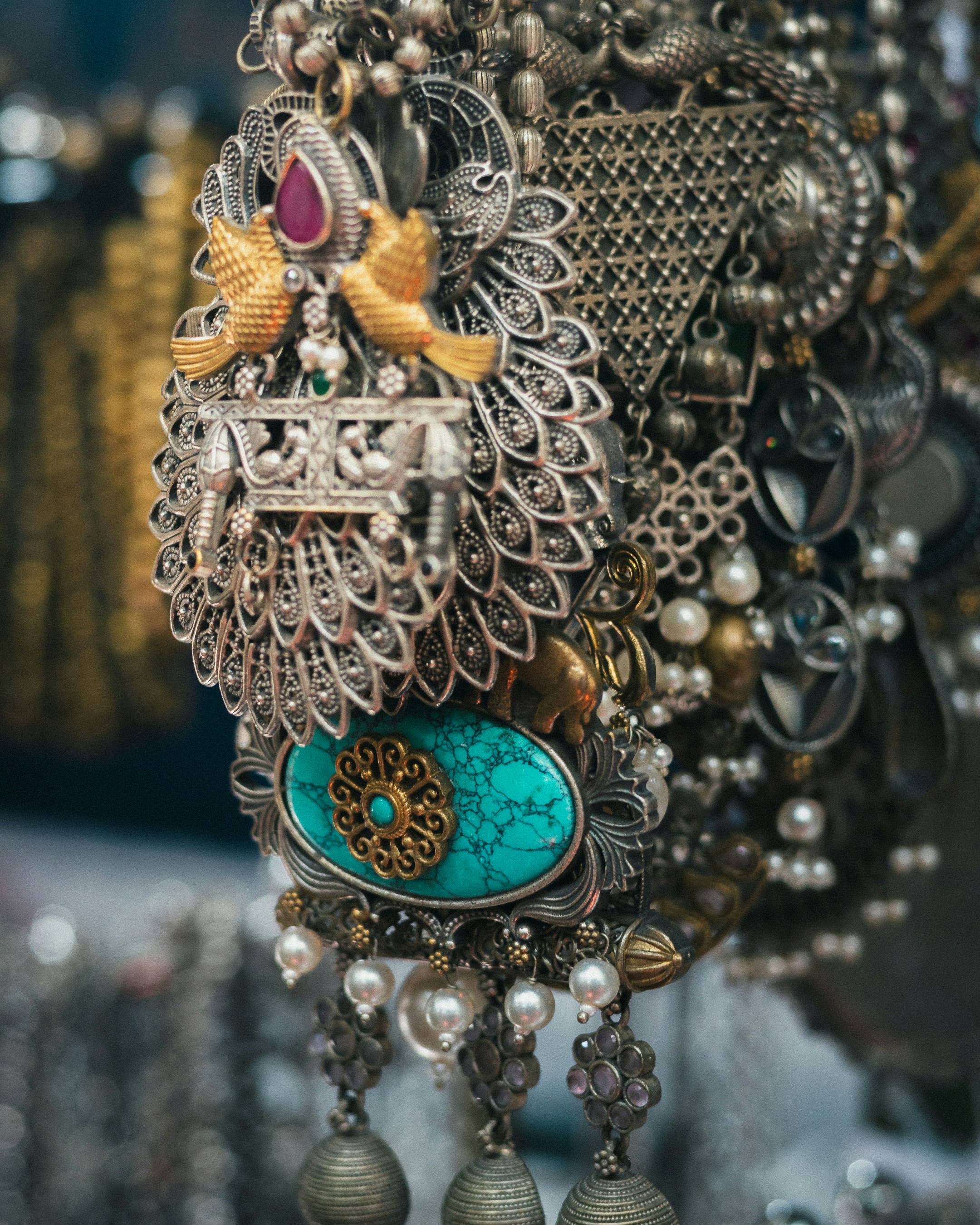 Intricate silver jewelry with turquoise and pearl accents.