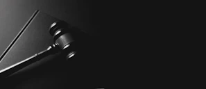 A gavel rests on a dark background.