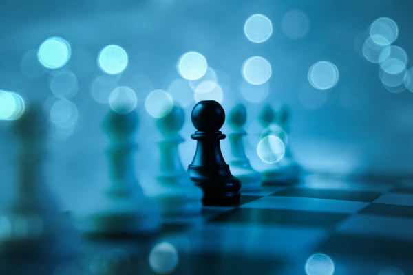 A black pawn stands out on a chessboard.