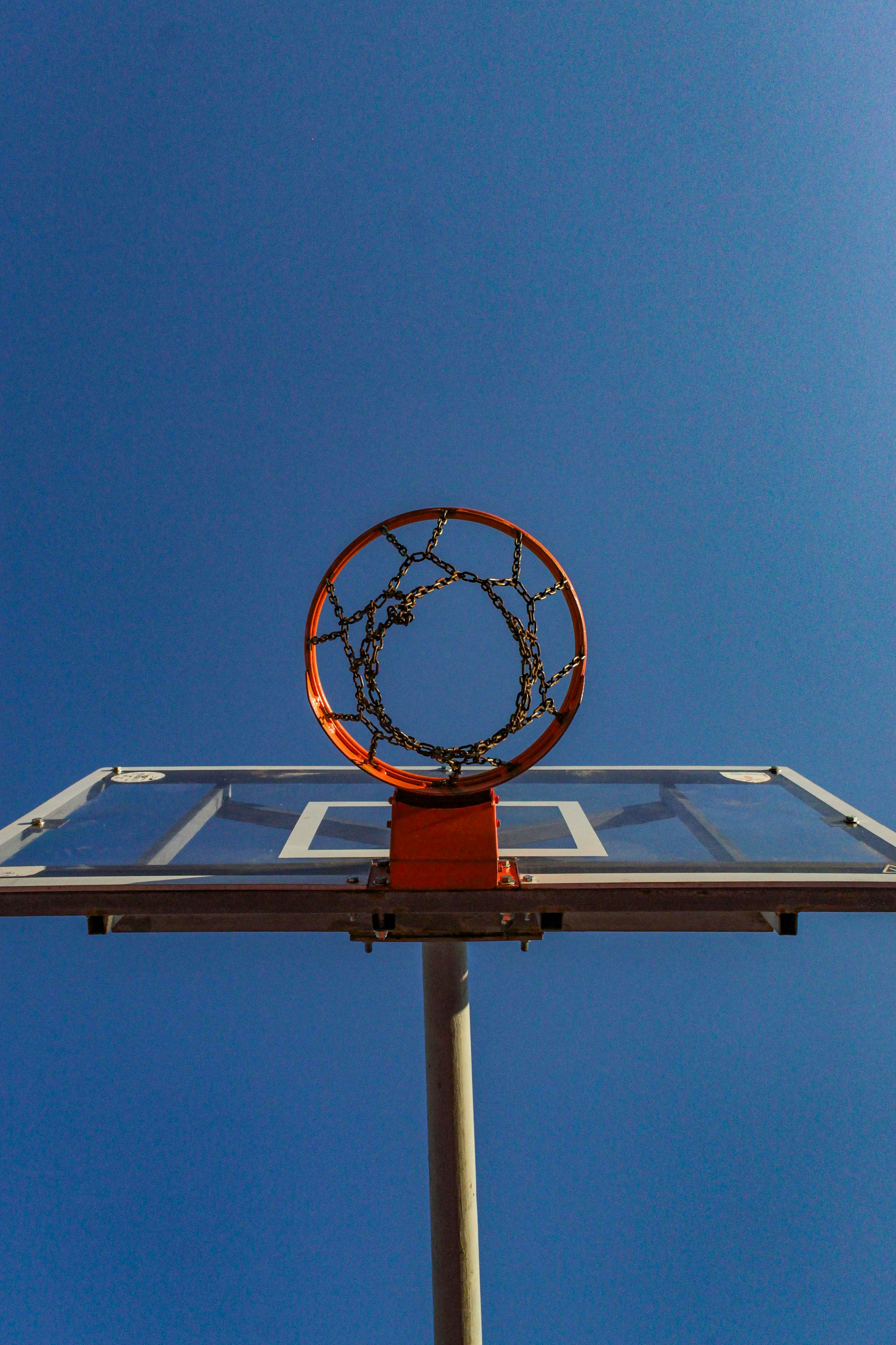 Basketball hoop against a clear blue sky.