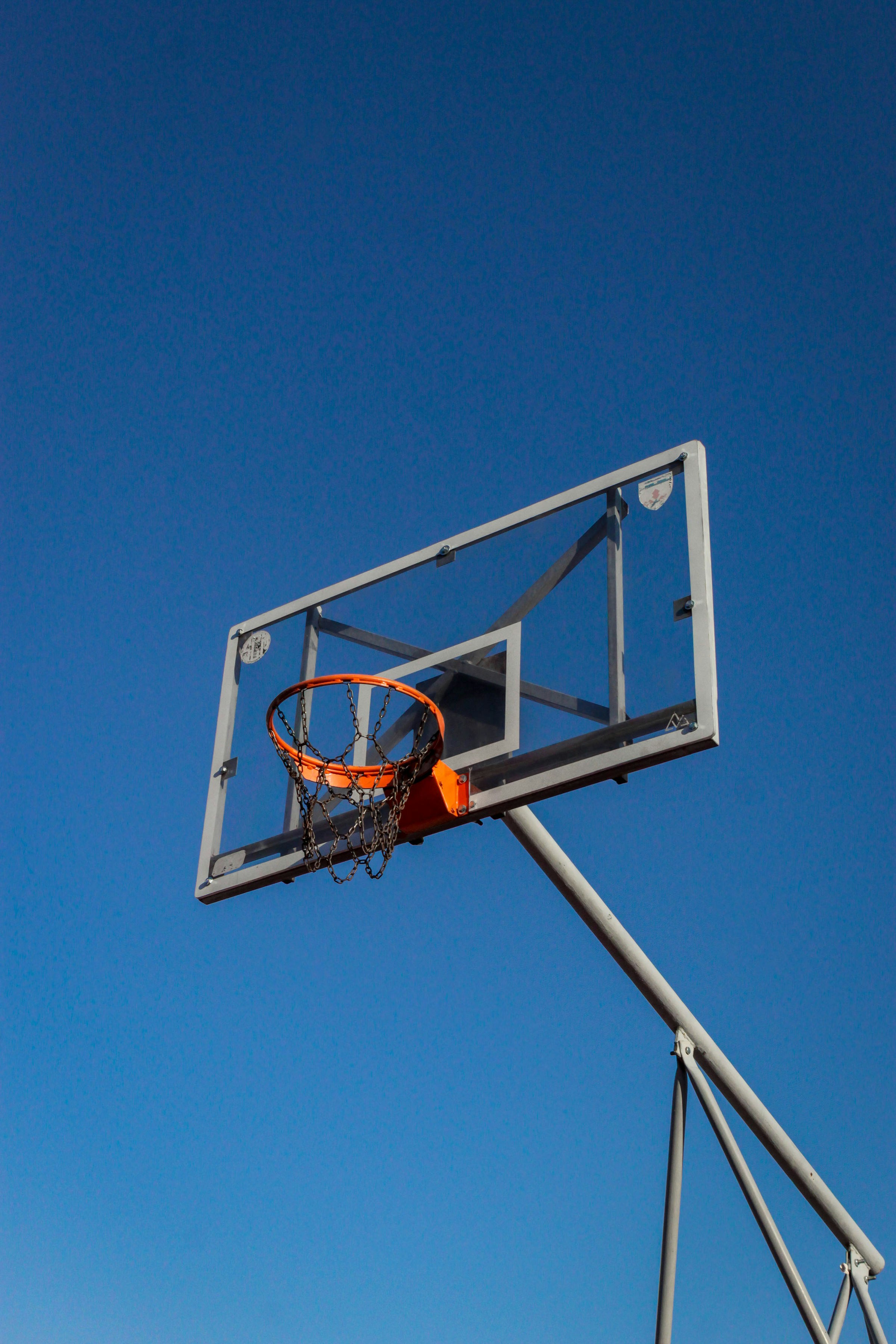 Basketball hoop against a clear blue sky.