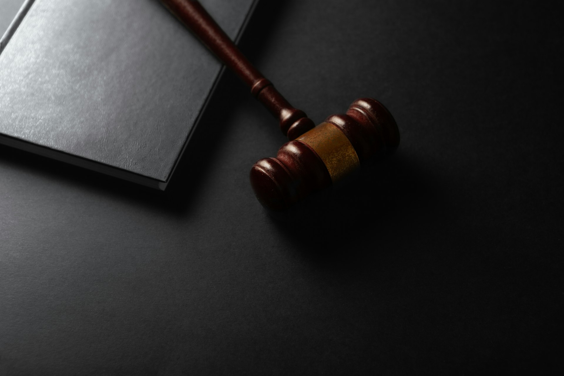A wooden gavel resting on a dark surface — representing legal proceedings and discovery