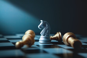 A white knight chess piece stands over fallen gold pieces.