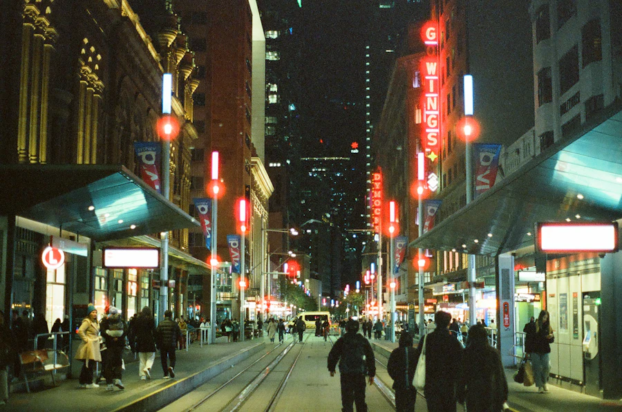 City street at night lit by neon signs, people walking