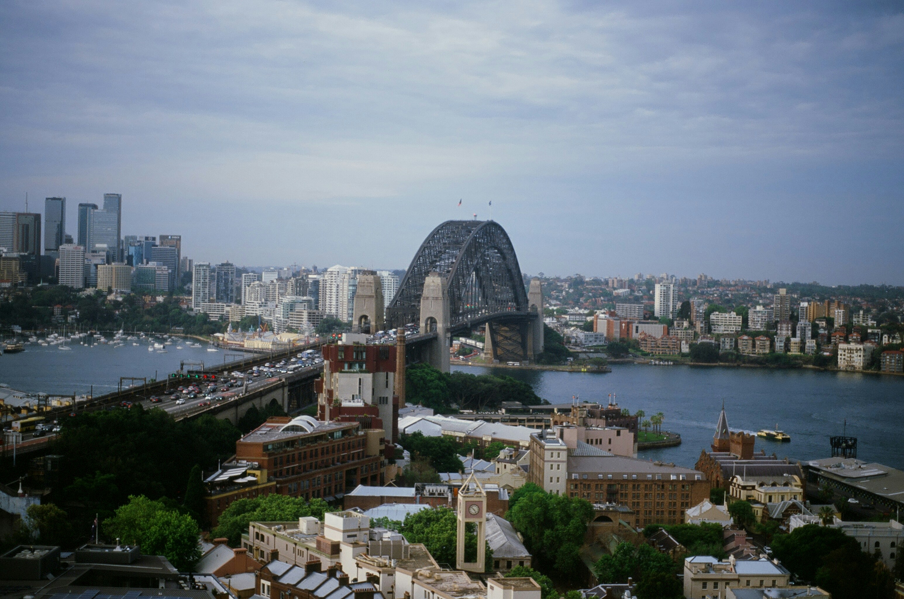 Sydney harbour bridge and city skyline under cloudy sky