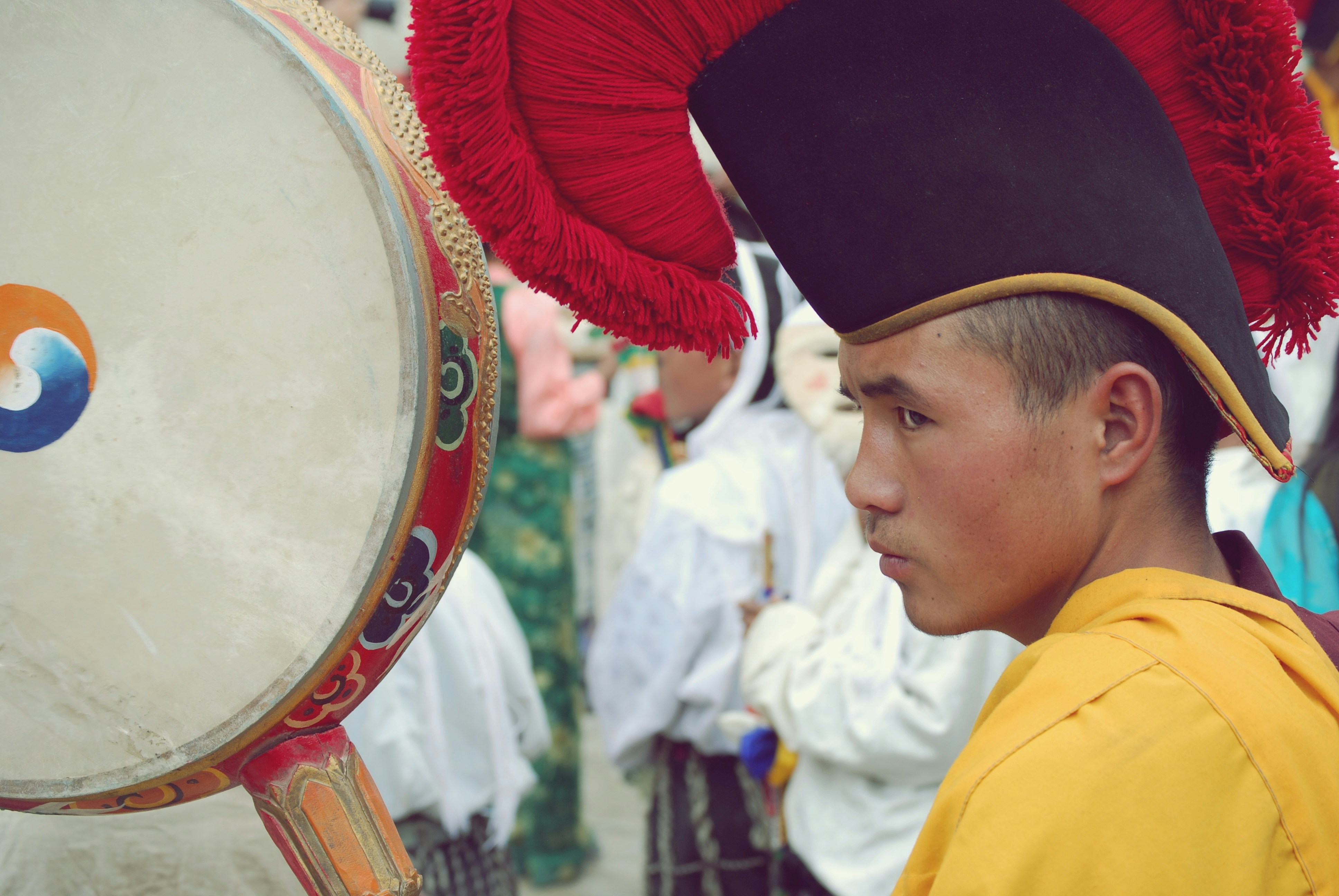 Homme au chapeau traditionnel et à la robe jaune avec tambour