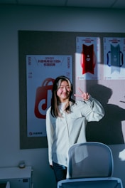 Young woman making peace sign in office