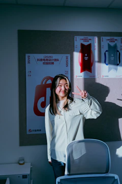 Young woman making peace sign in office