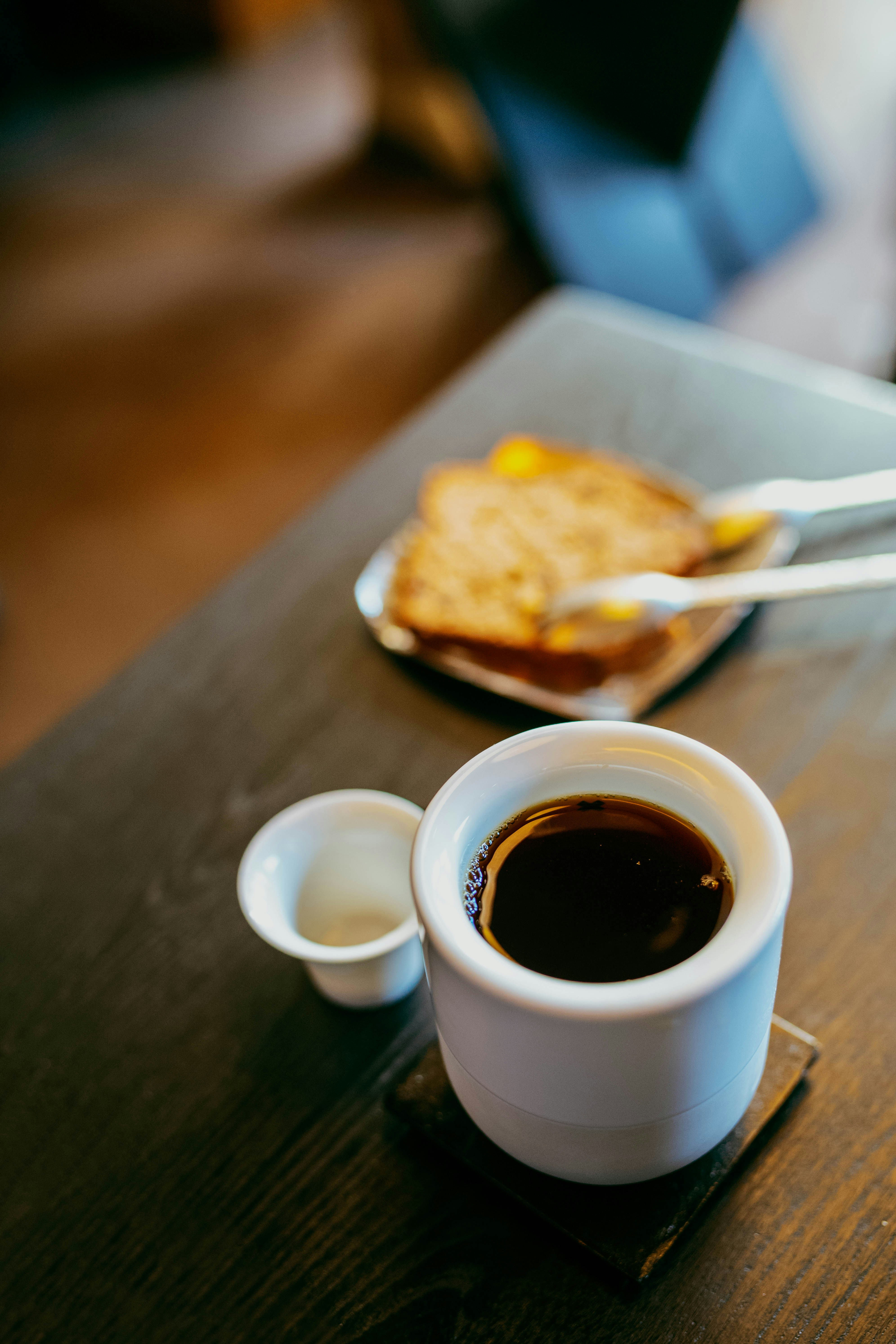 A cup of coffee and a sandwich on a table