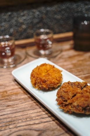 Two fried croquettes on a white plate