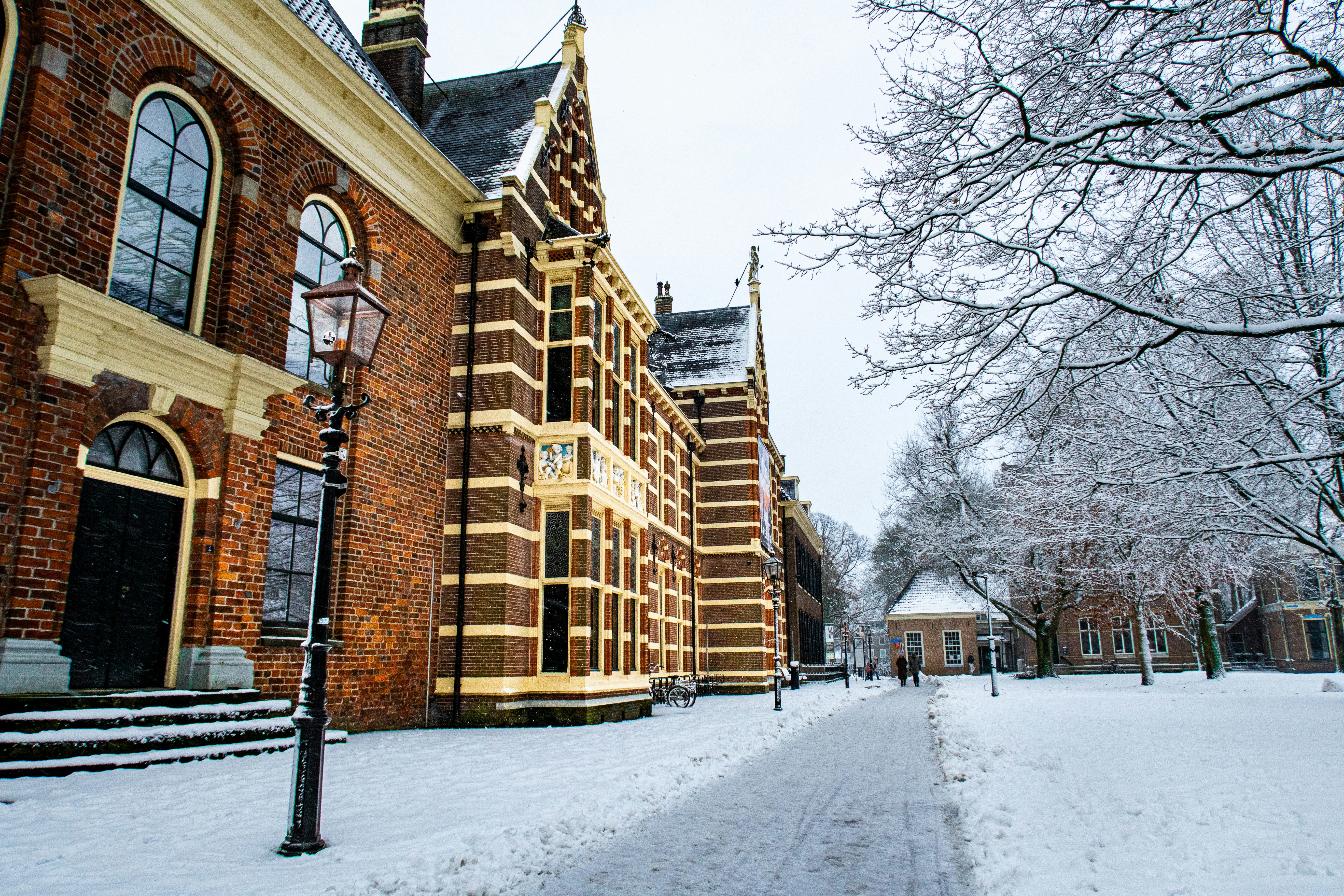Historic brick building in a snowy park setting