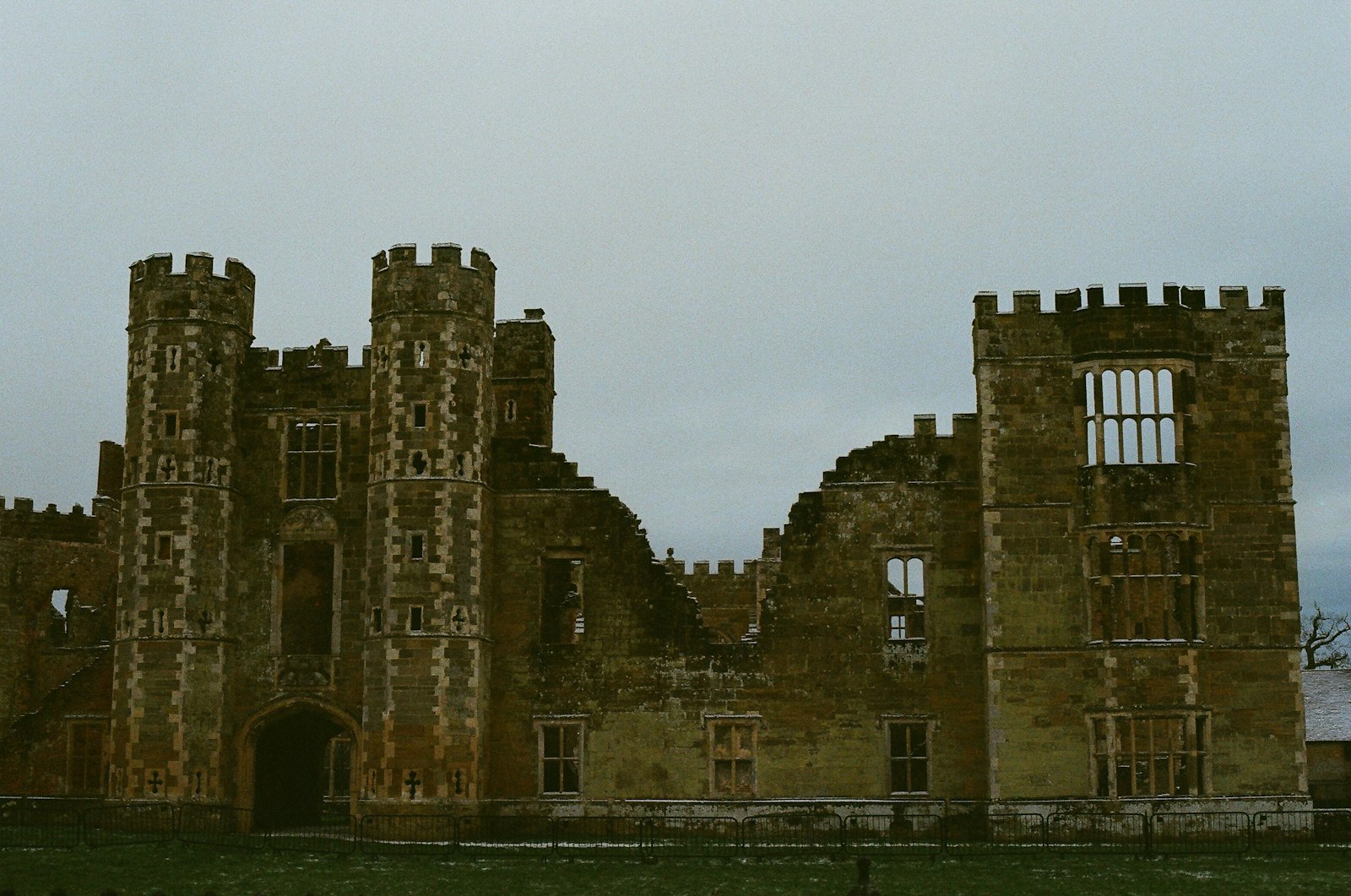 Ruines d'un chateau aux murs de pierre effrondres sous un ciel d'hiver