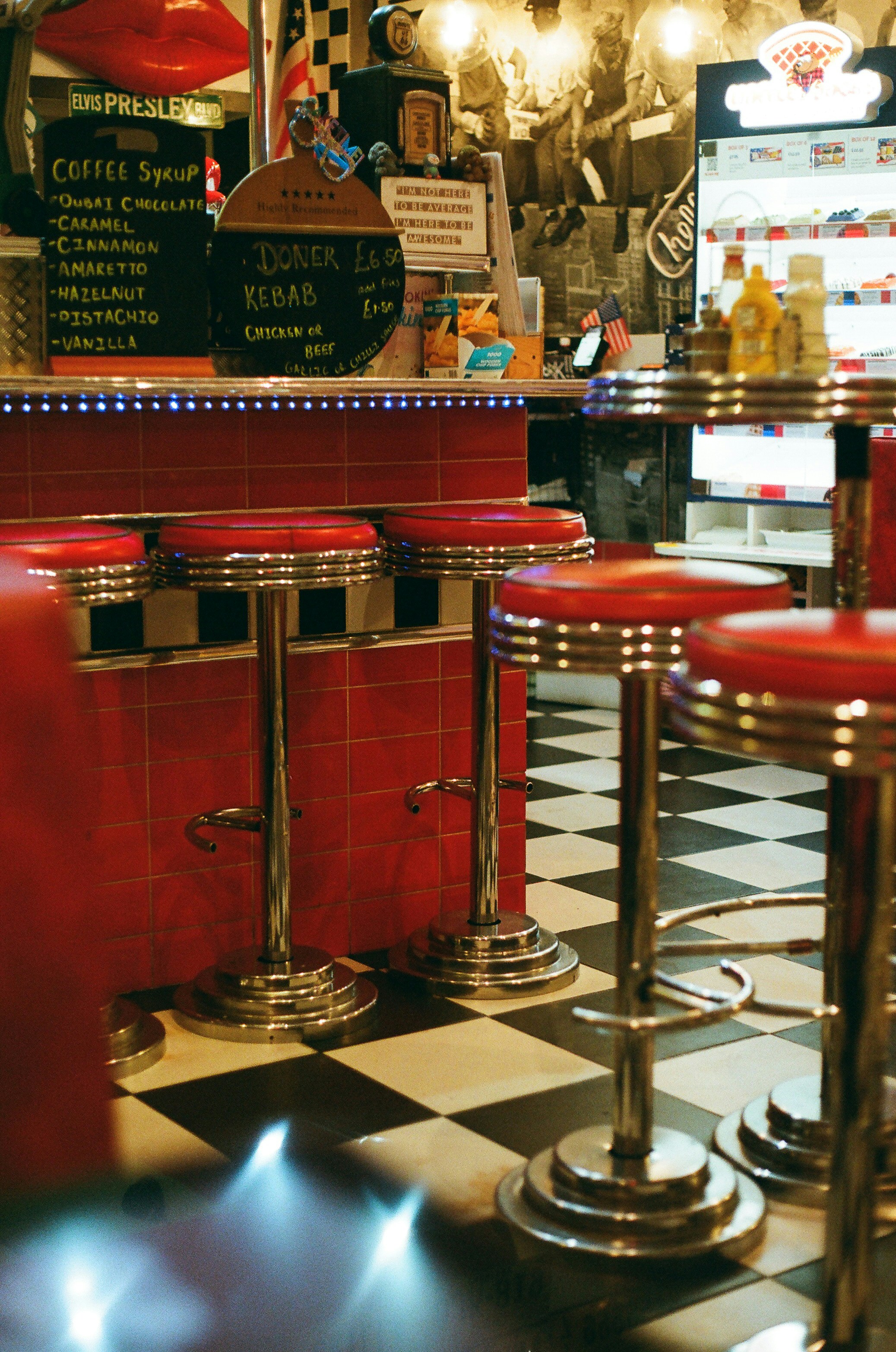 Retro-Diner mit roten Hockern und kariertem Boden.