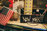 American flag and "new york" sign on shelf