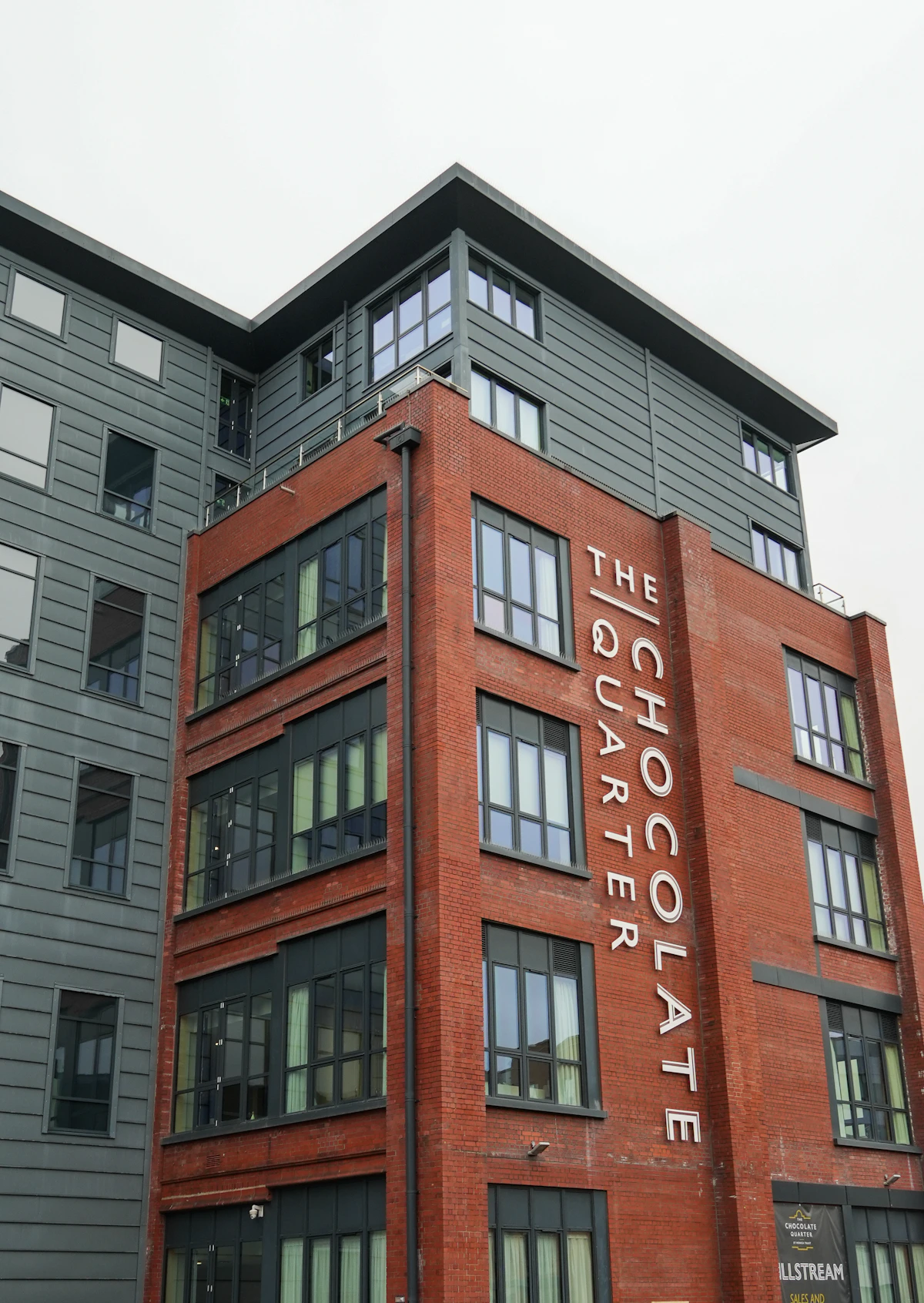 Modern mixed-use commercial development with retail storefronts and residential units above