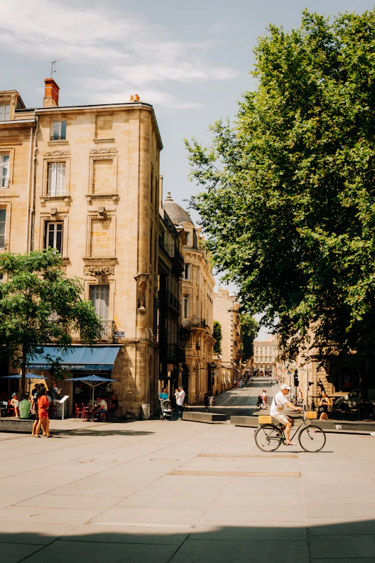 Man rides bicycle through sunny european square