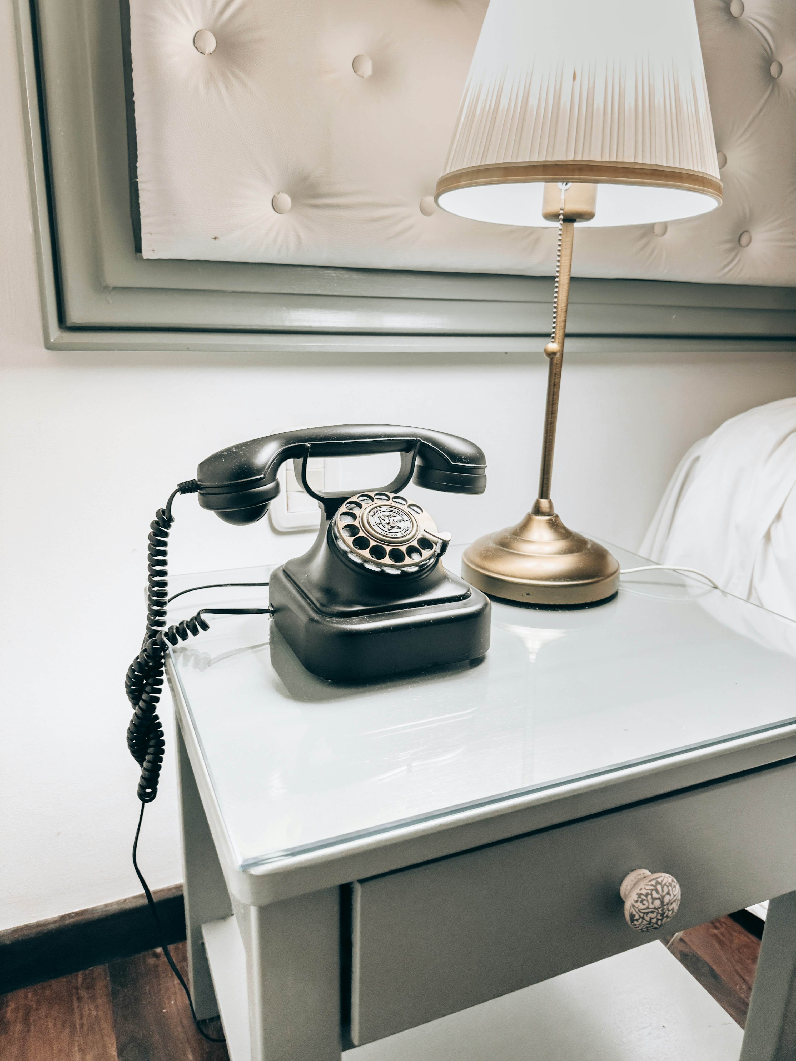 Vintage rotary phone and lamp on nightstand