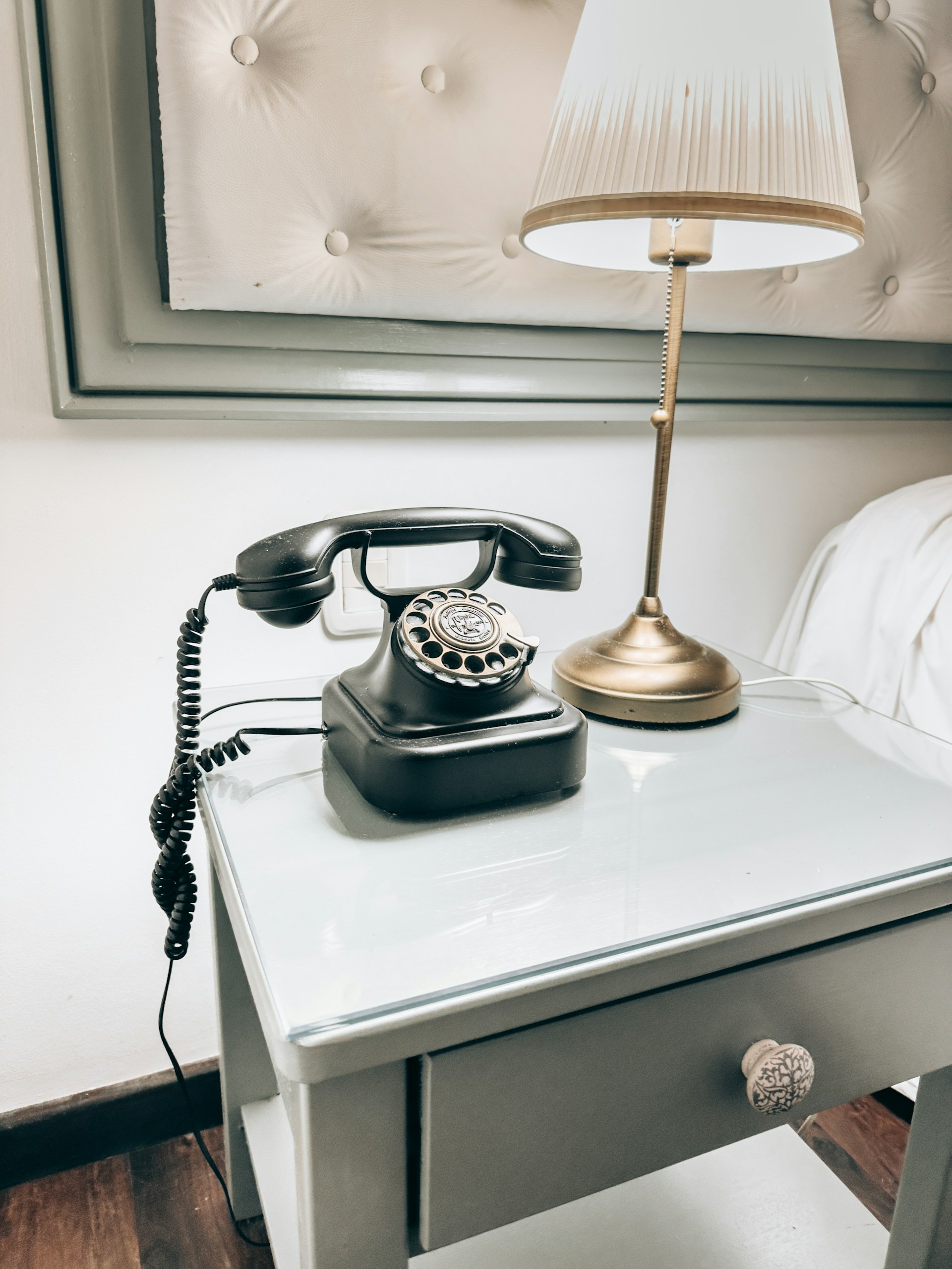 Vintage rotary phone and lamp on nightstand