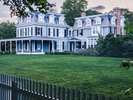 Two large historic houses with manicured lawns.