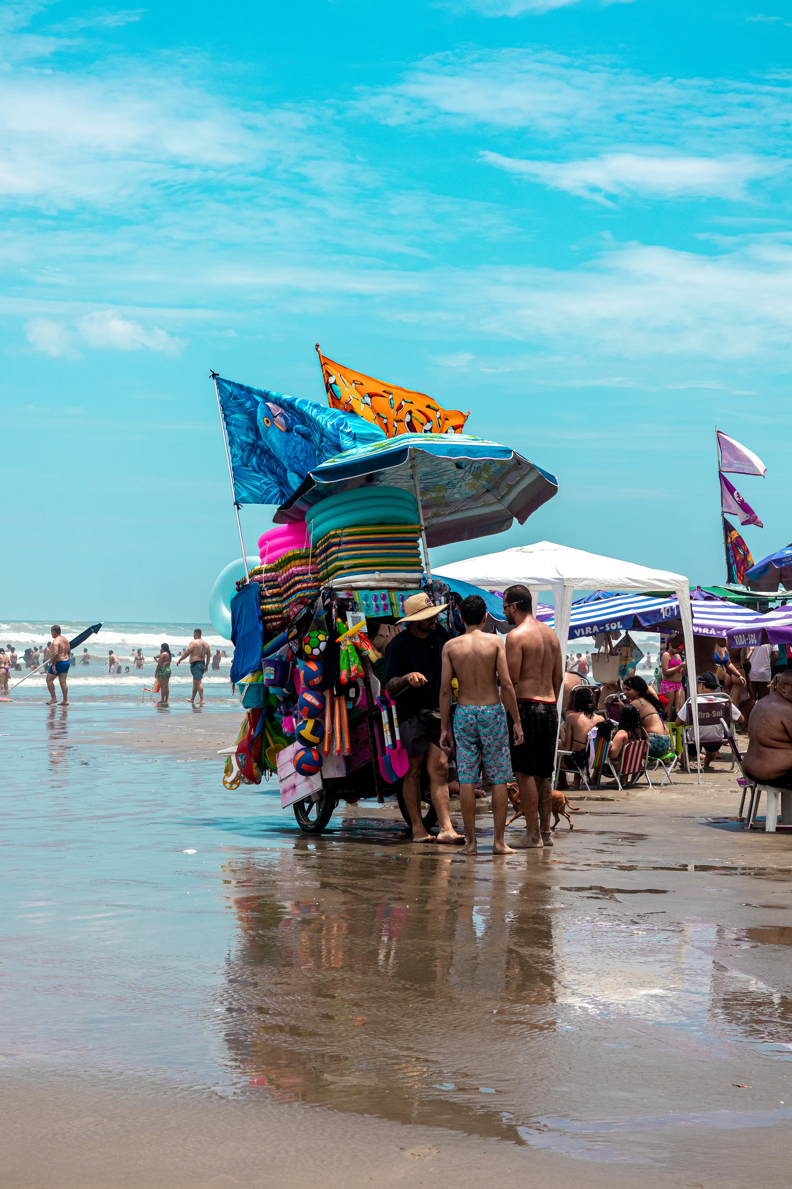 Strandverkäufer, die bunte Handtücher und Souvenirs verkaufen