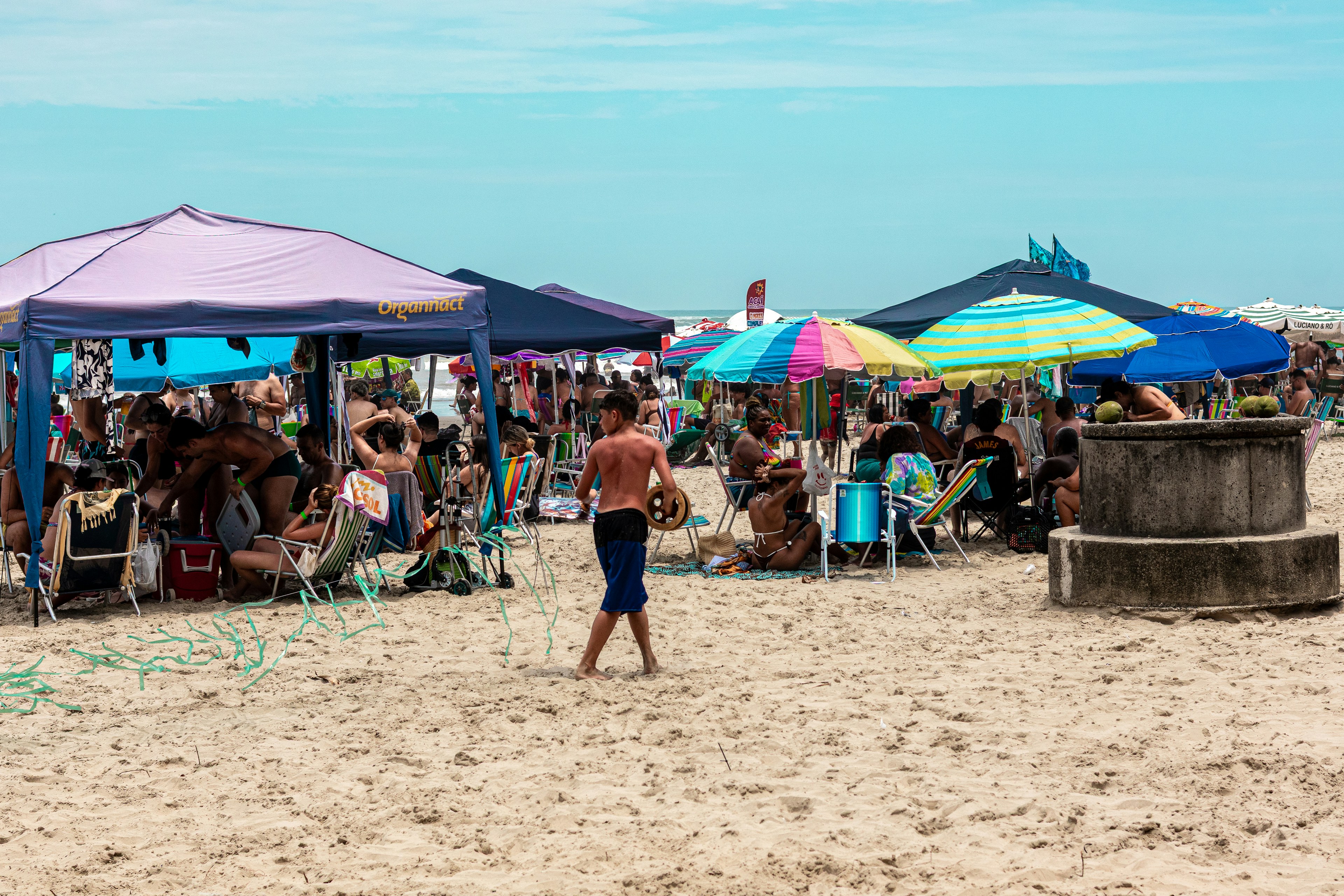 People relaxing under umbrellas on a sunny beach.
