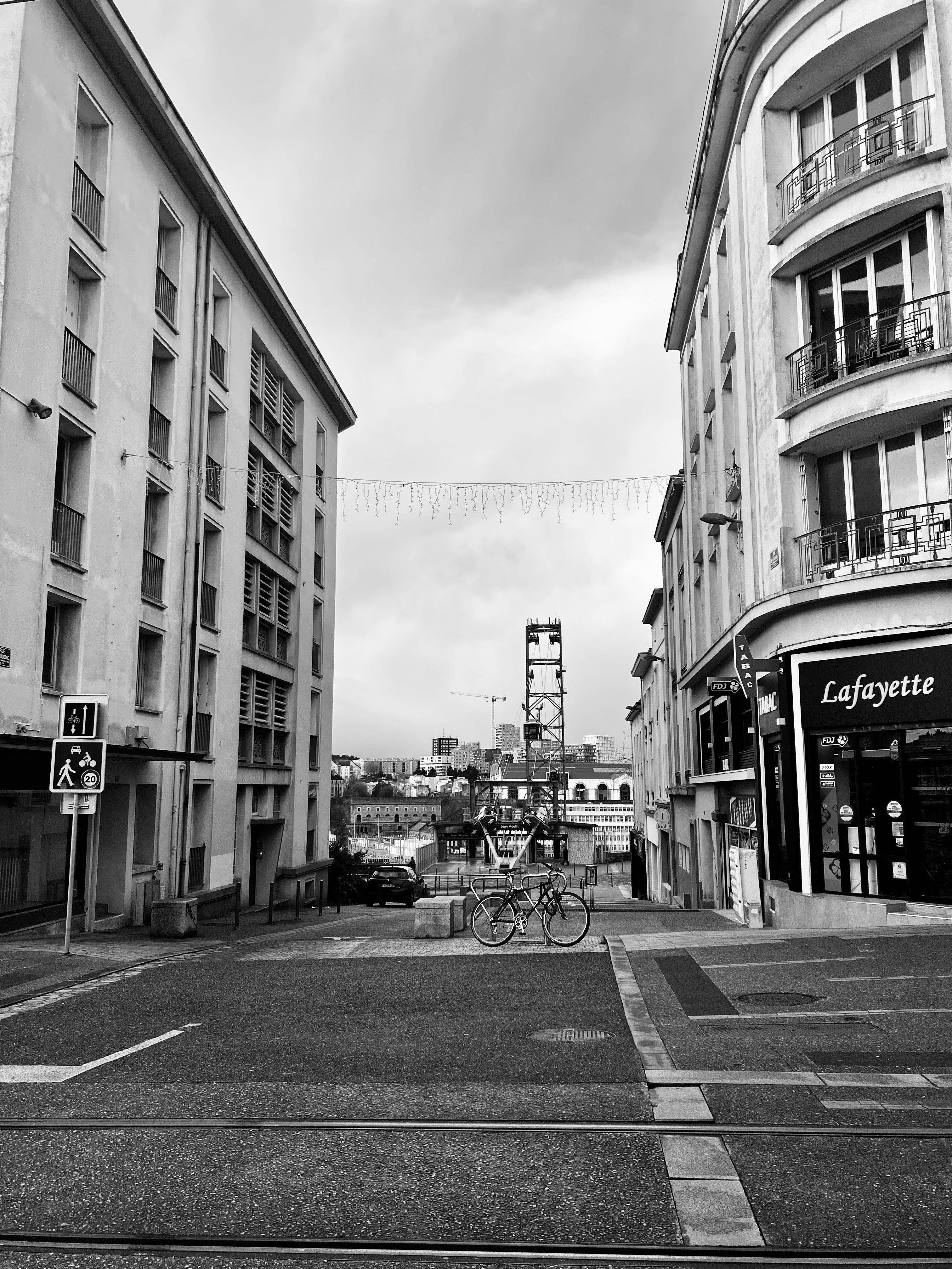 Two bicycles parked on a street in a city.