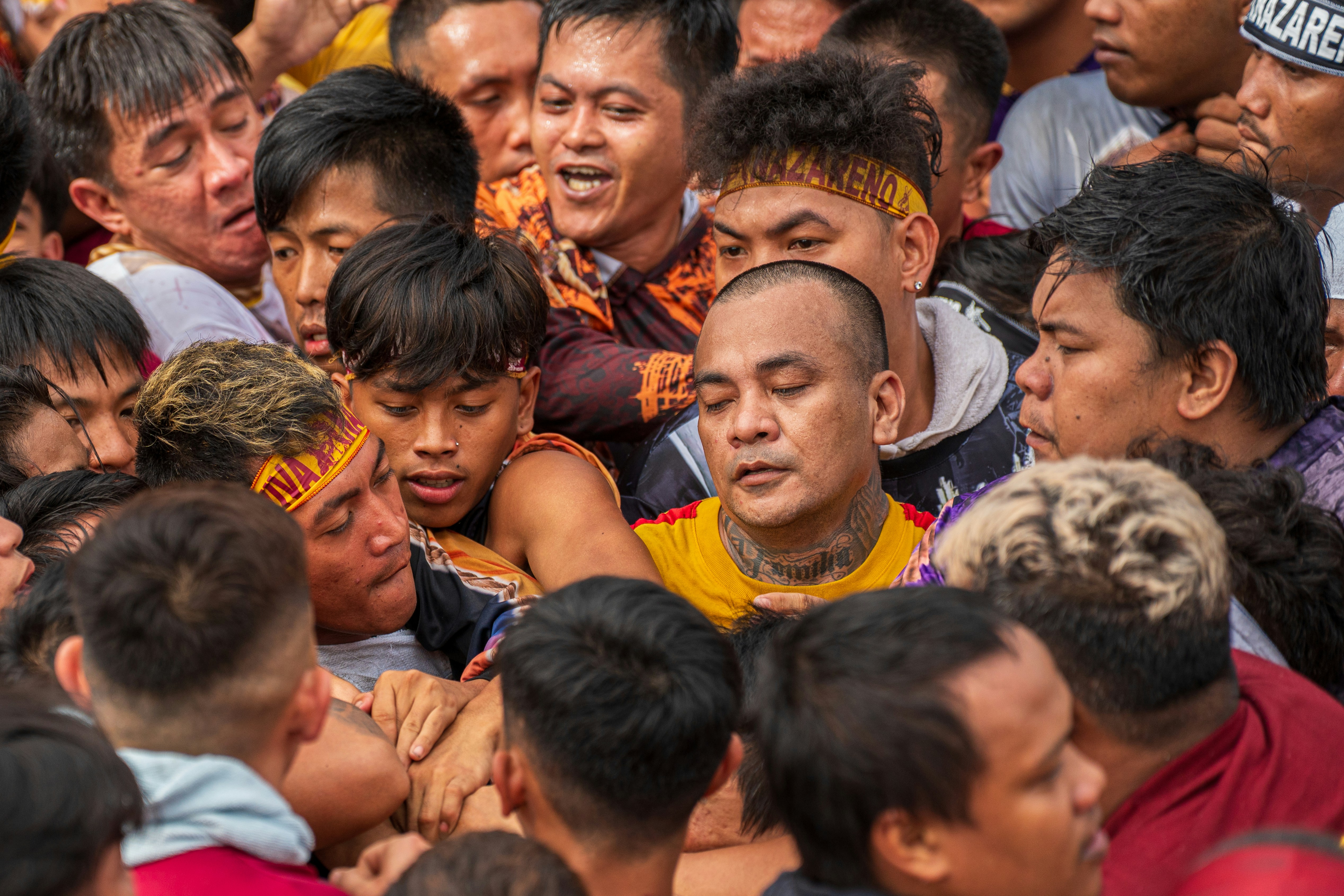 Crowd of men in close proximity during an event.