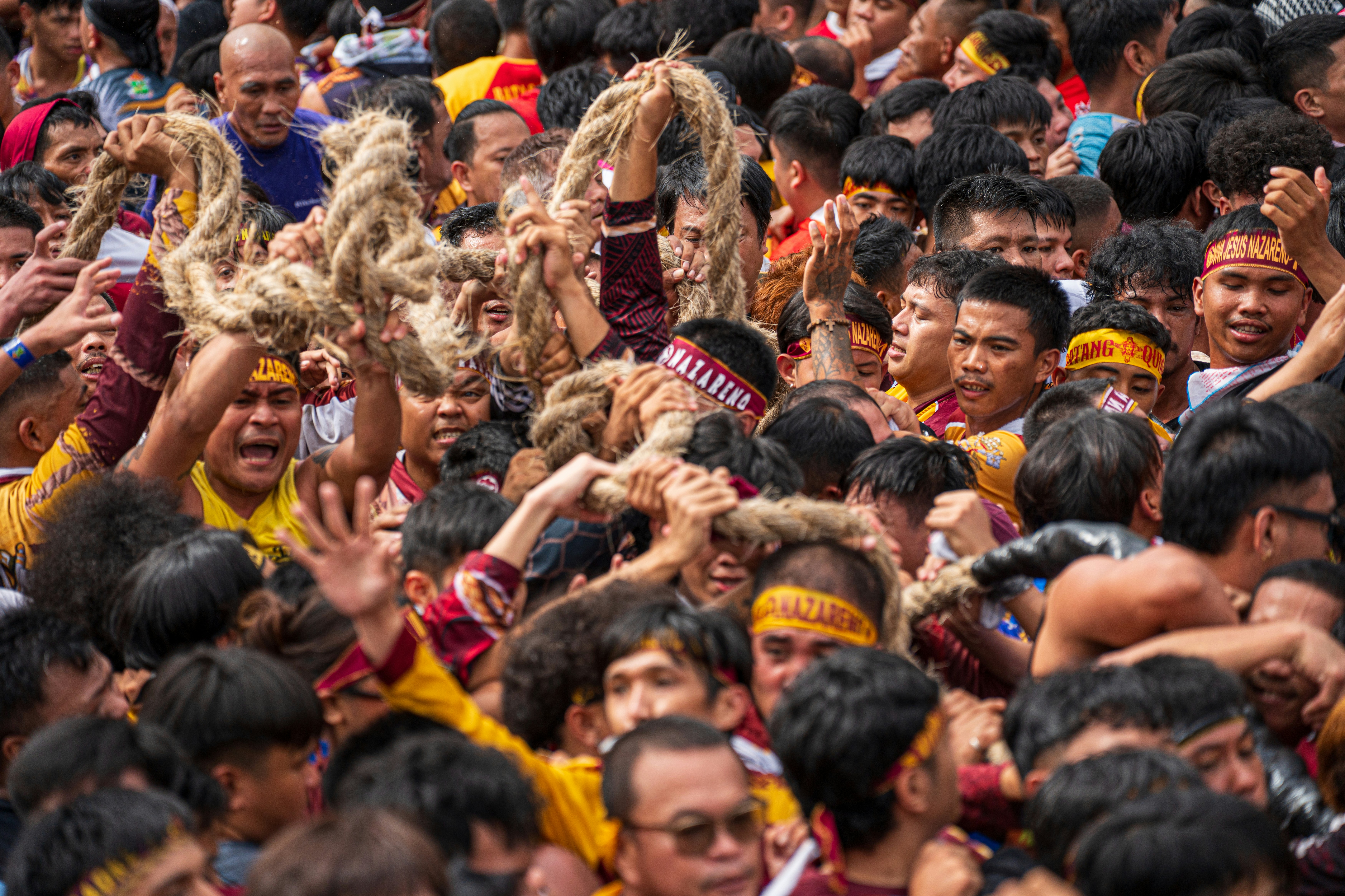 Crowd of people carrying a heavy rope during a festival