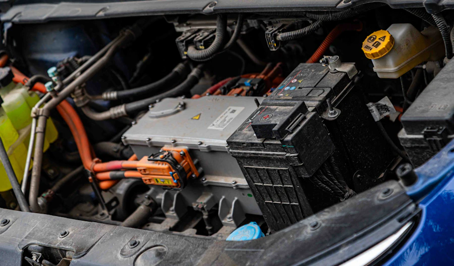 An electric vehicle battery pack with visible wiring and power electronics after removal.