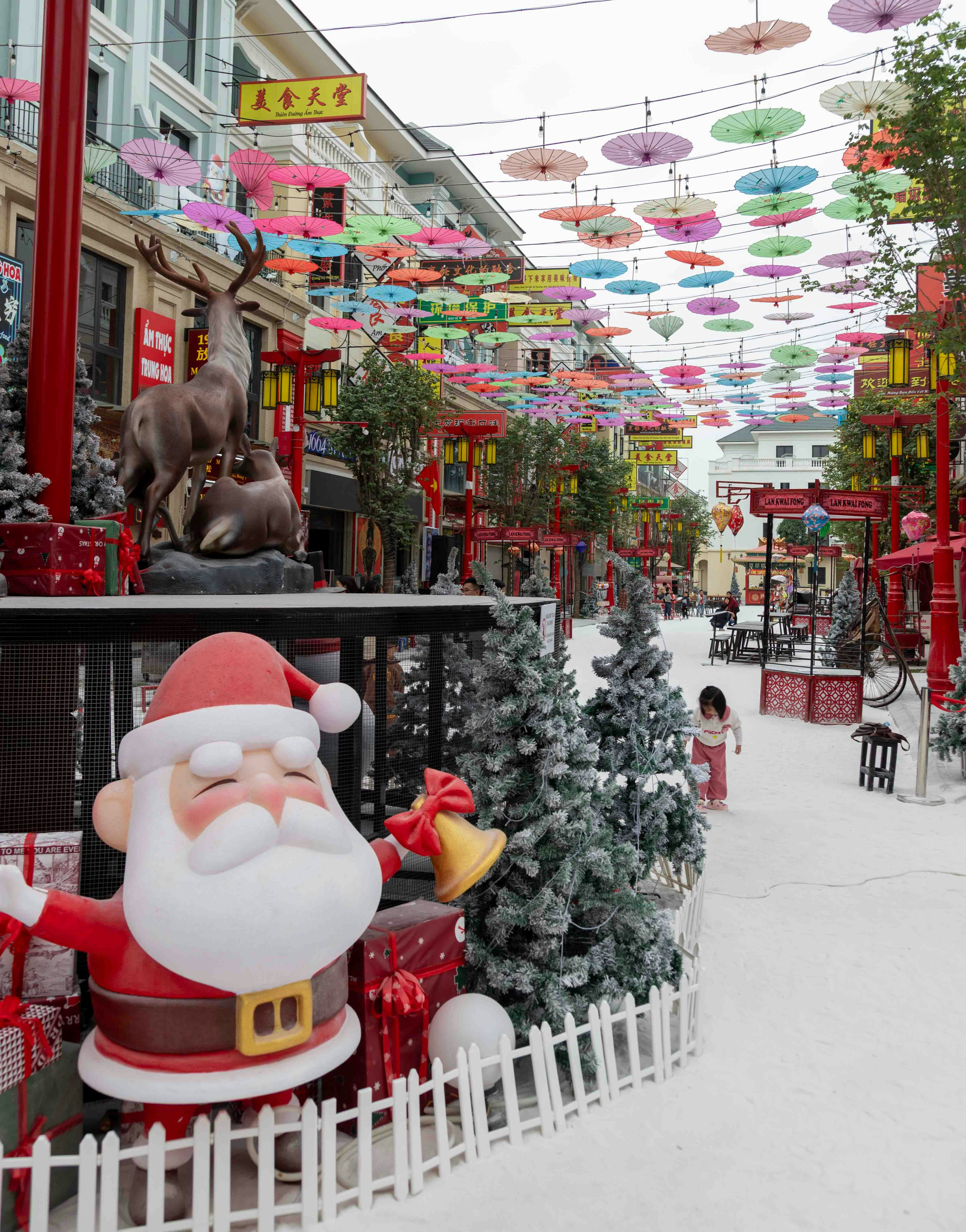 Decorazioni di Babbo Natale su una strada con ombrelli colorati.