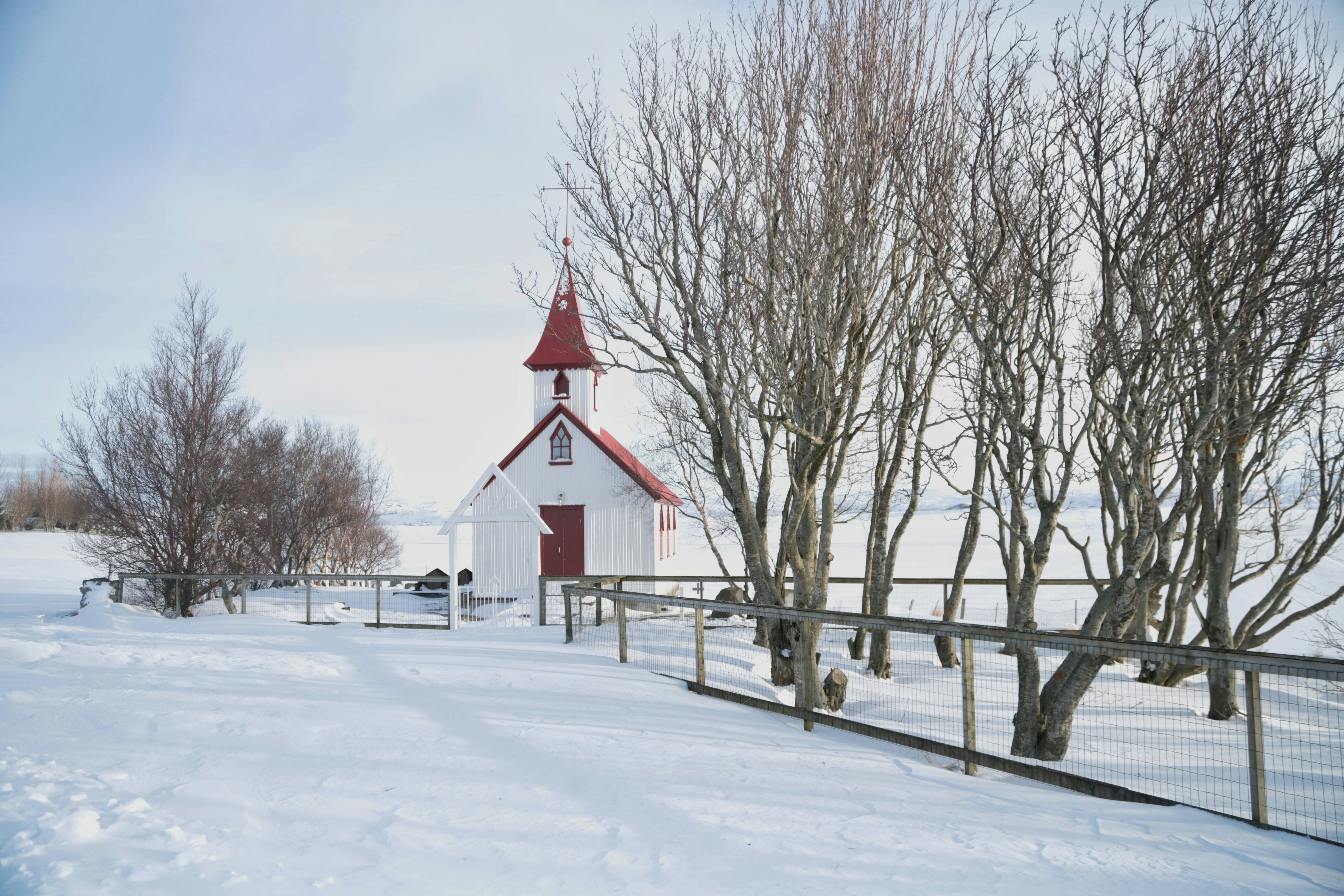 Small white church with red roof in snowy landscape