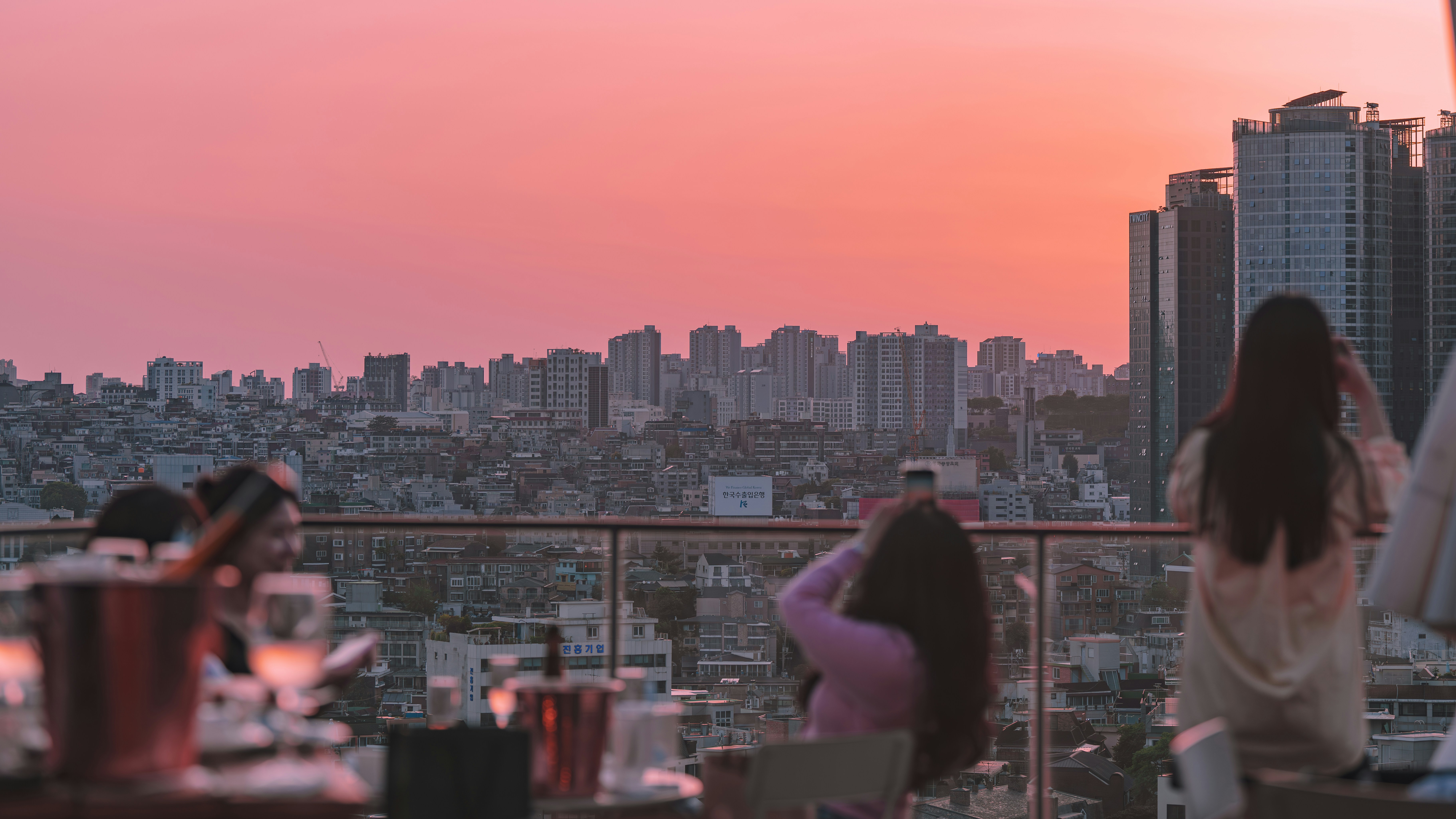 People enjoying sunset over city skyline from rooftop
