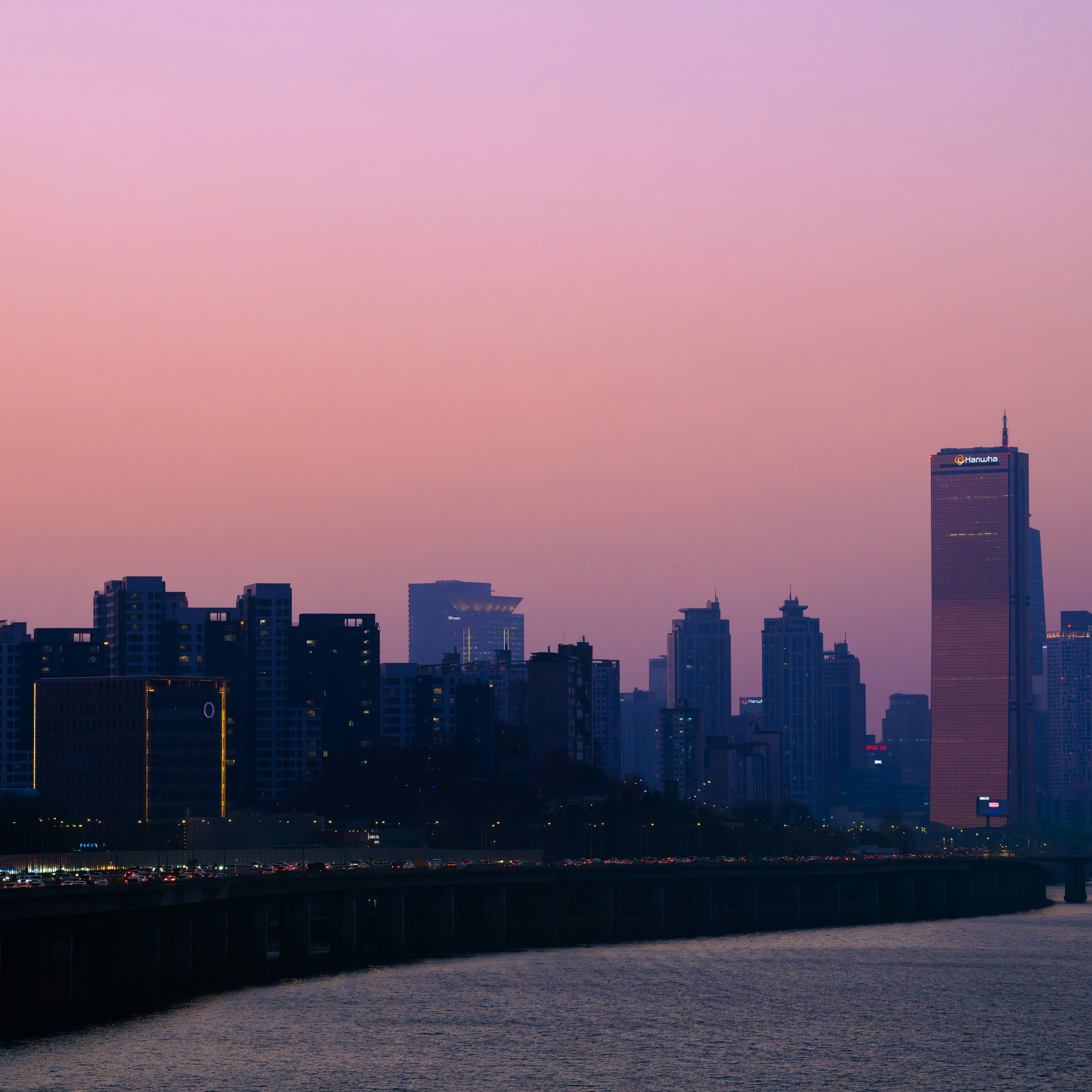 City skyline at sunset with a purple sky.