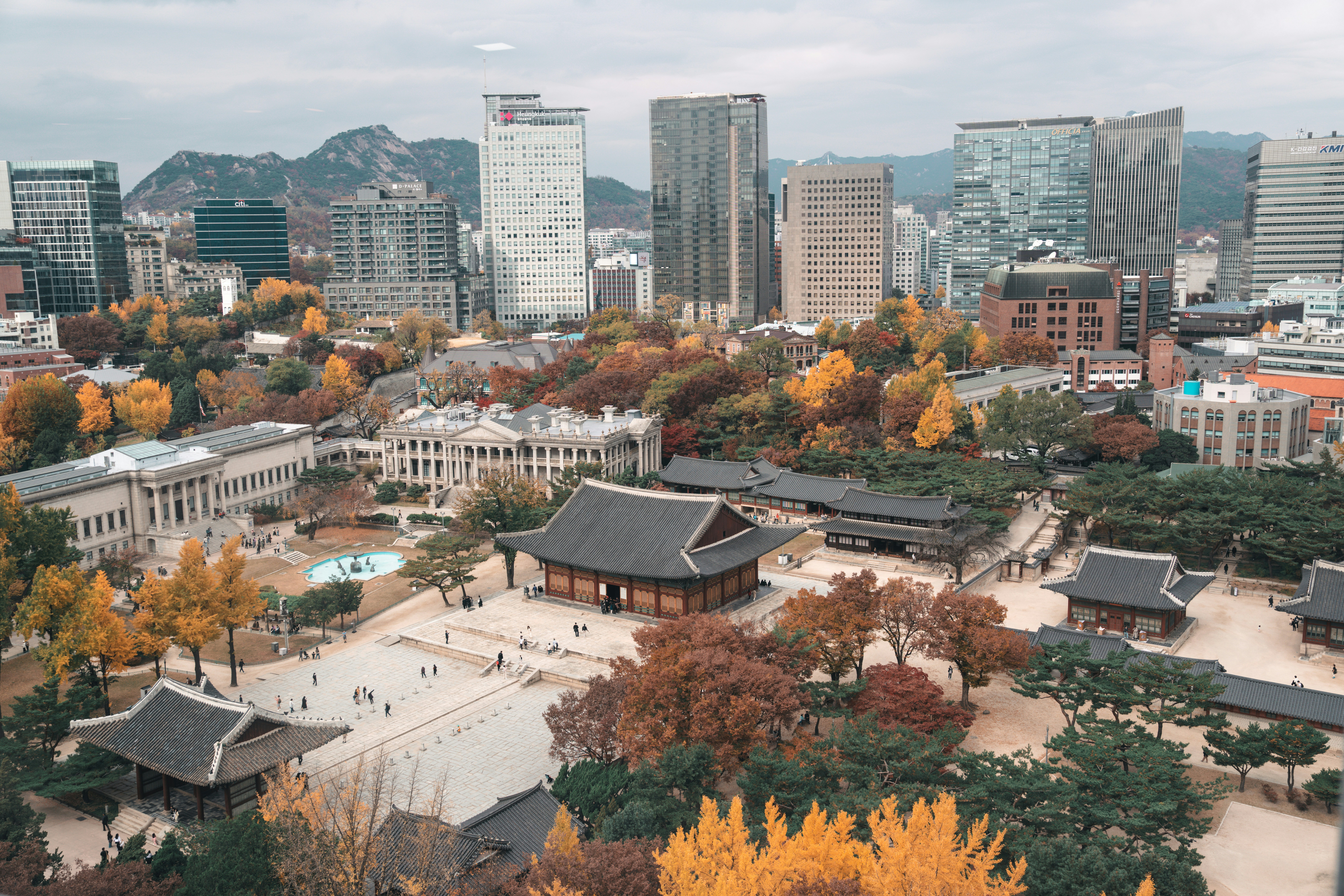 Traditional korean palace buildings with modern skyscrapers in background.