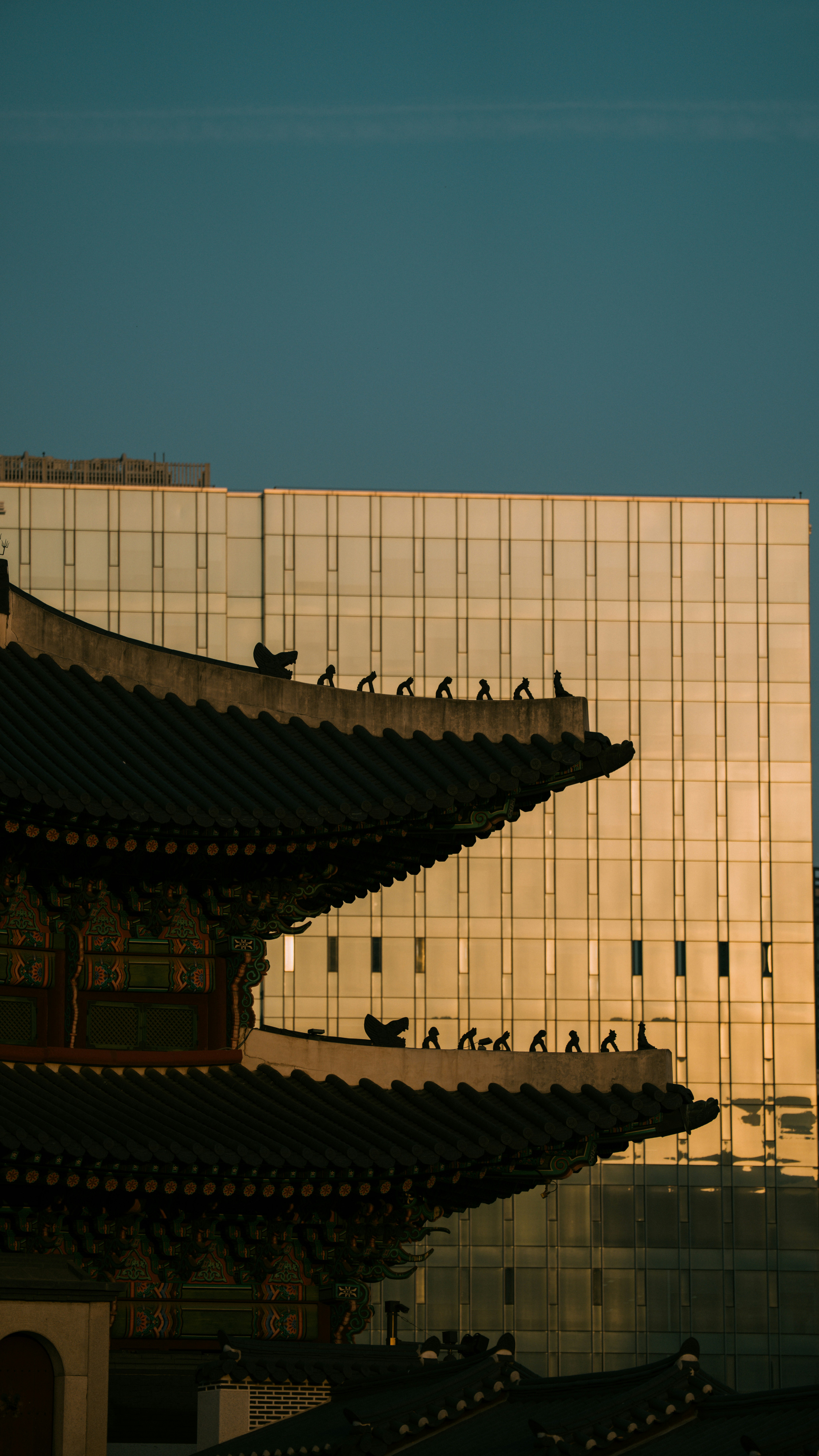 Traditional korean architecture against a modern glass building.