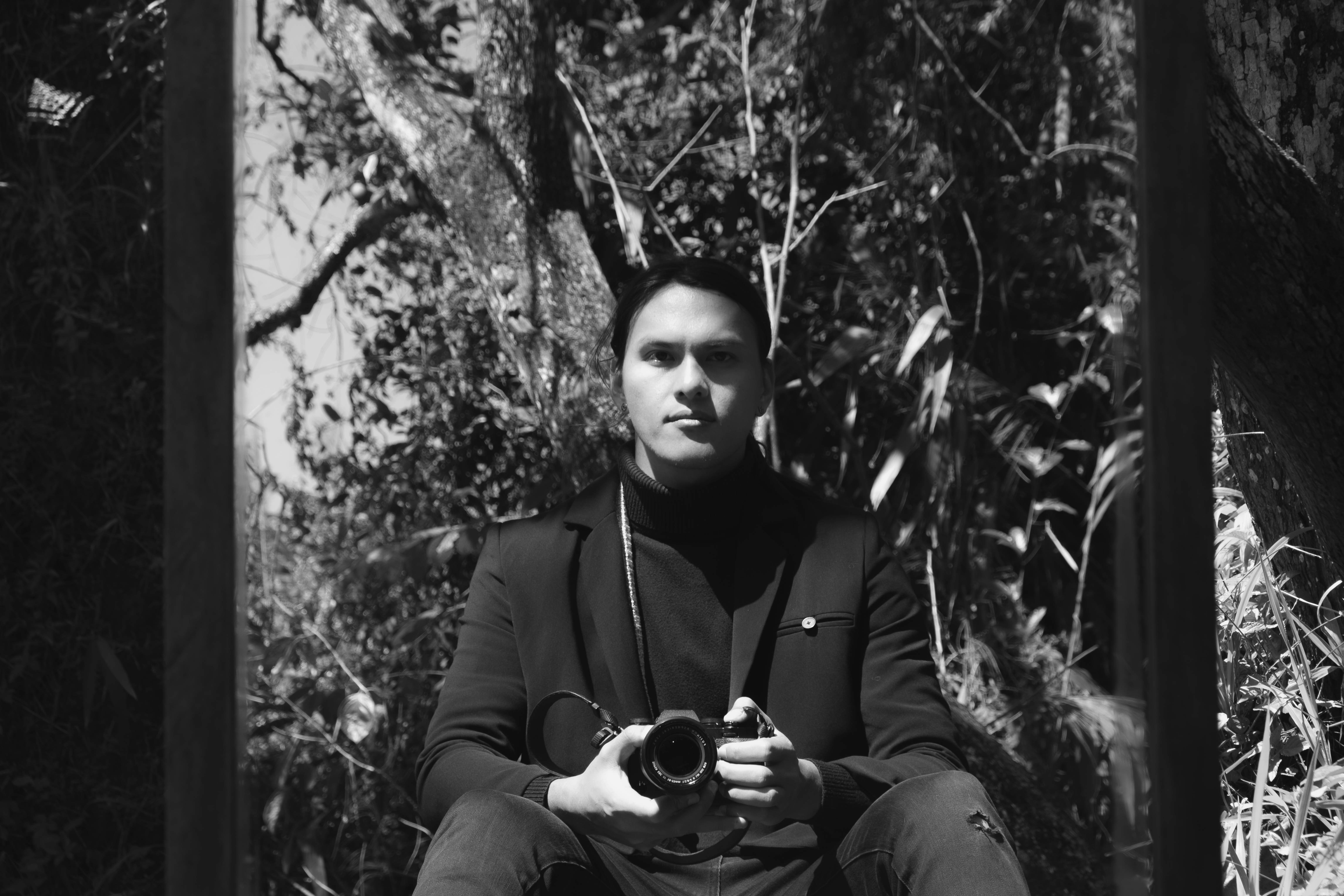 Man holding camera in a forest