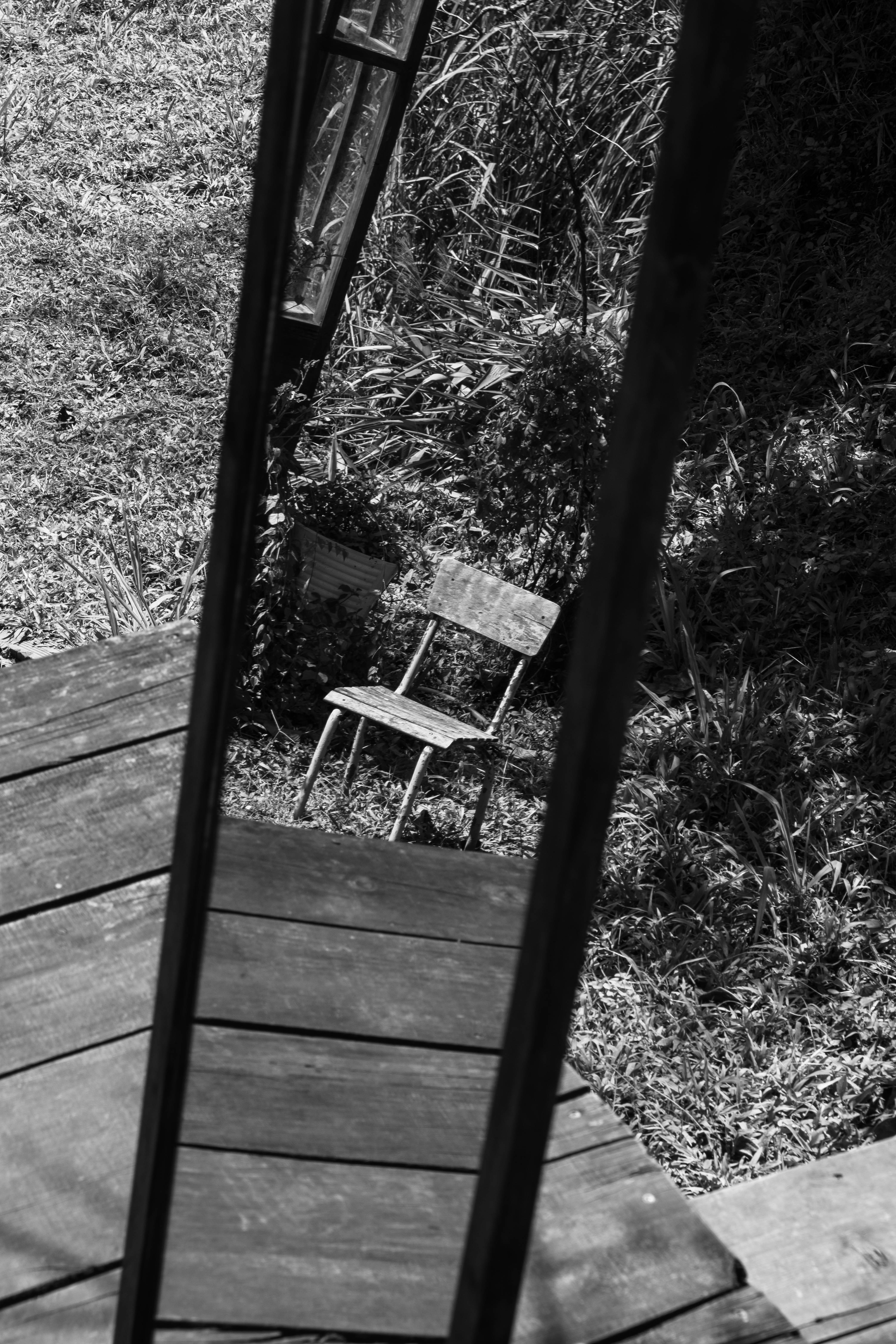 Old chair reflected in a mirror outdoors
