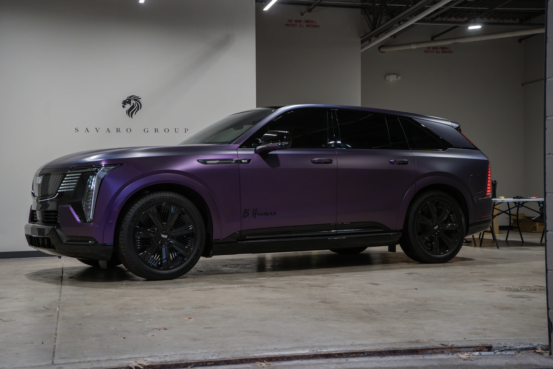 A purple cadillac suv parked indoors.