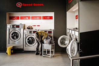 Person working in a modern laundromat with washing machines.