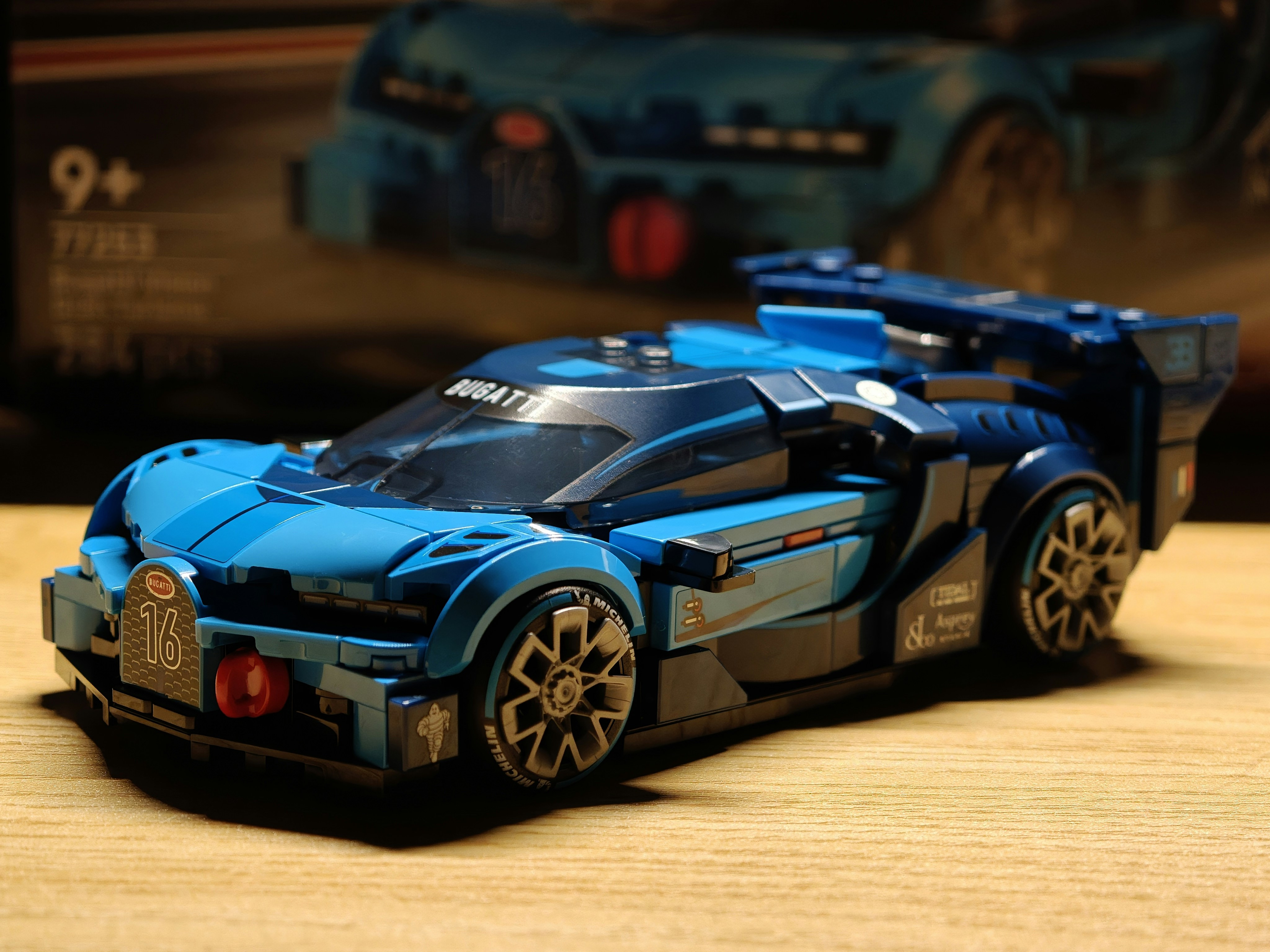 A blue lego car on a wooden surface