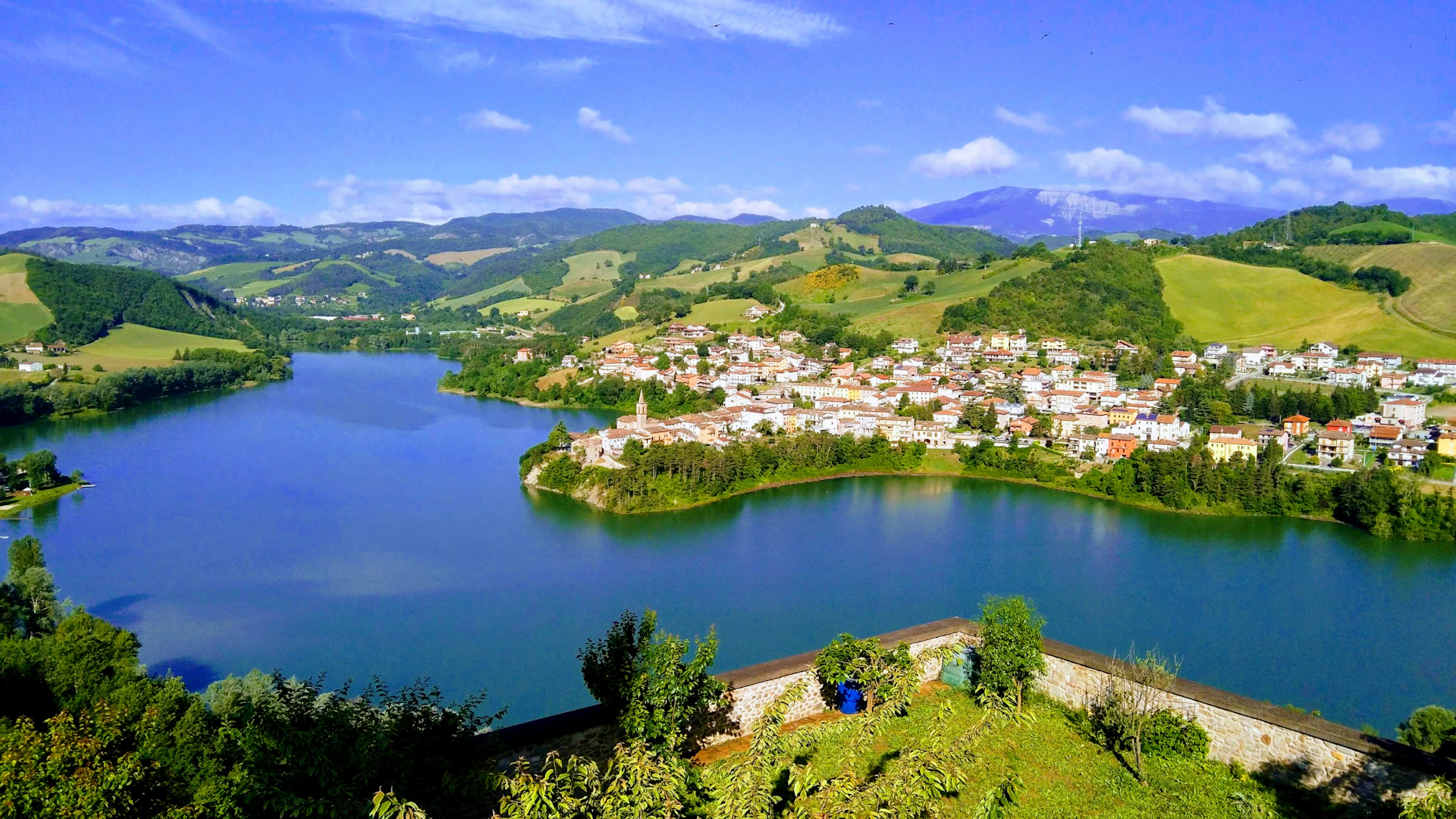 A serene lake beside a small town in the hills.